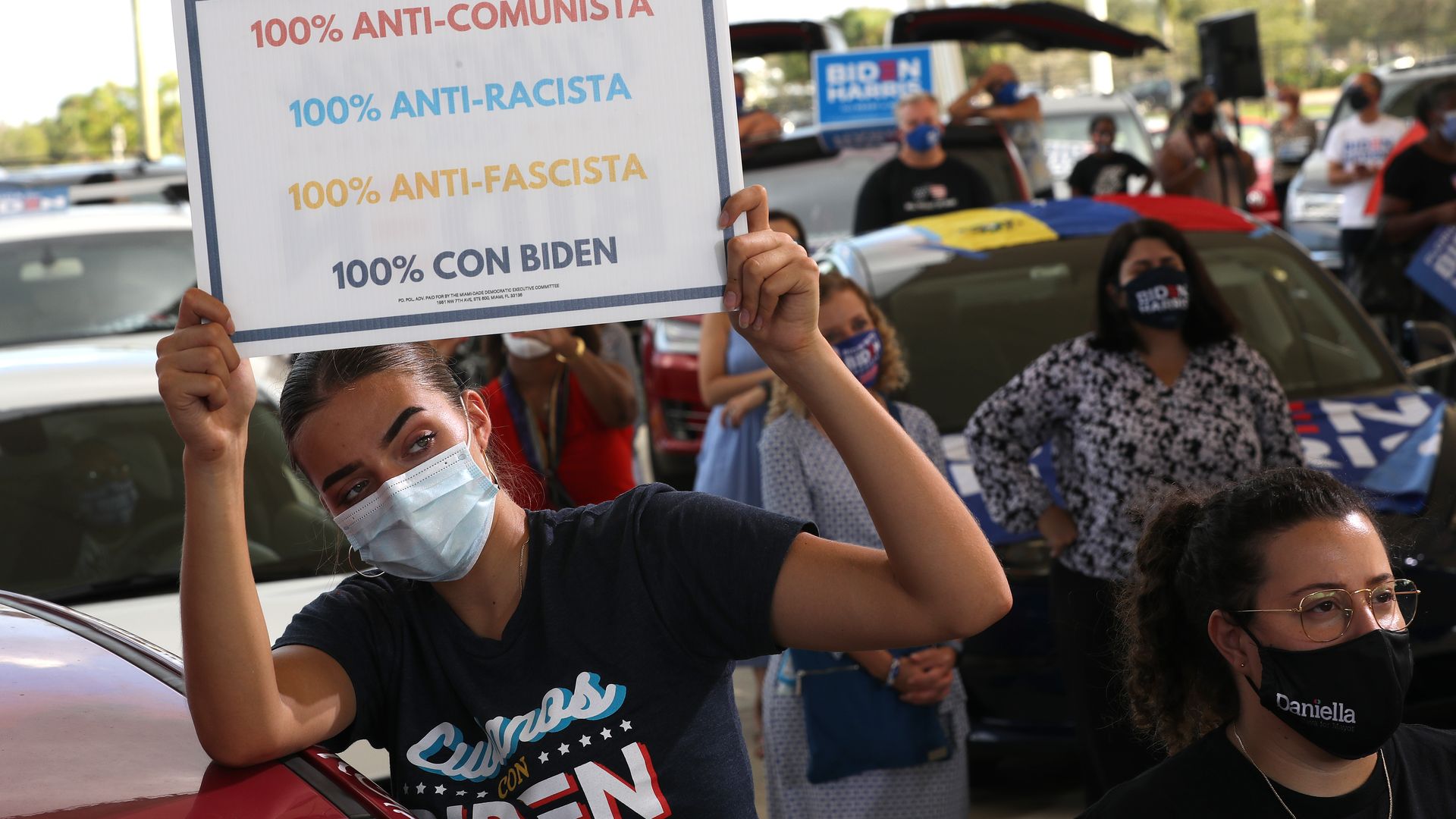 Photo of a Biden/Harris supporter holding up a sign in Spanish that urges people to vote for Biden