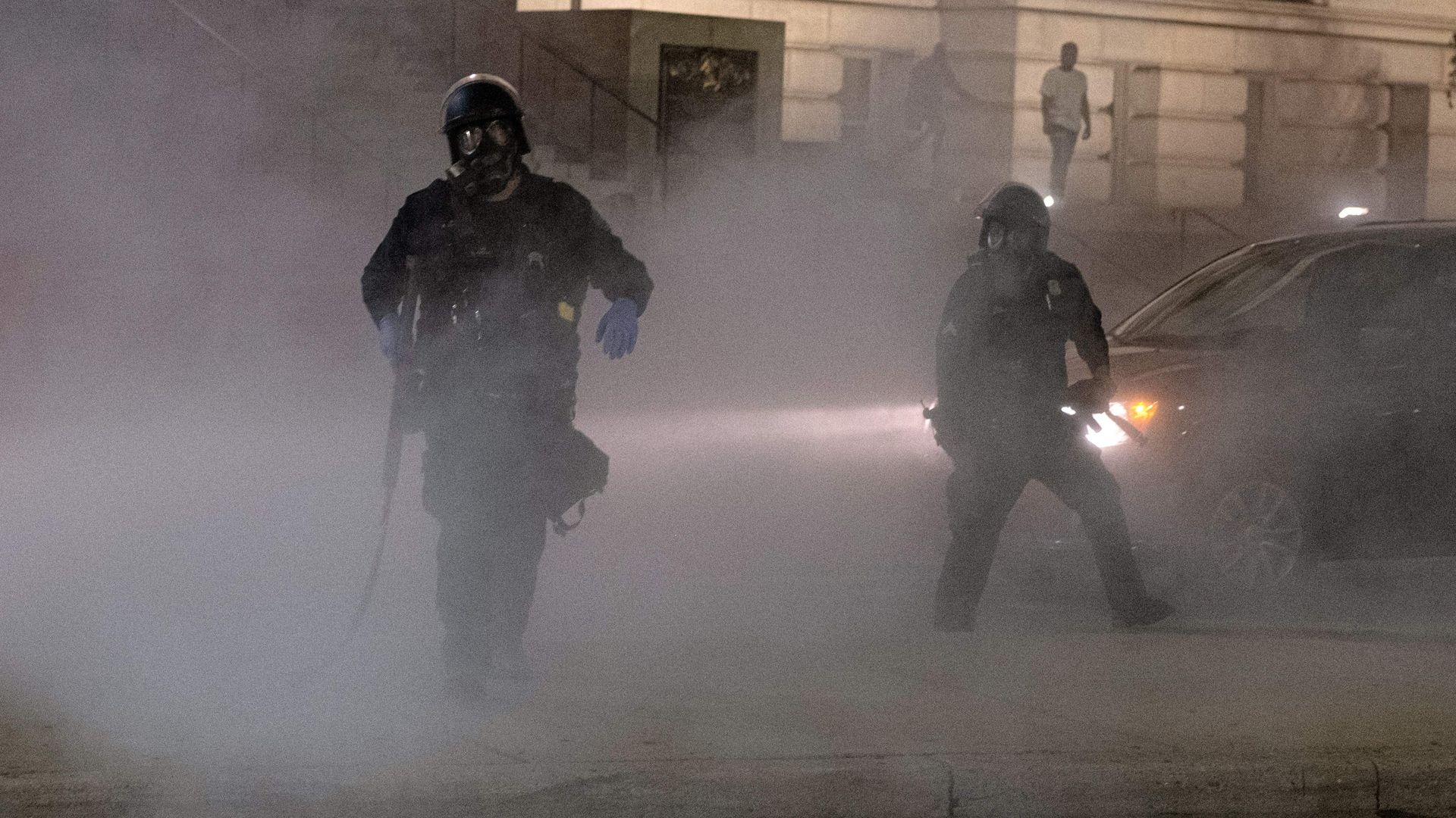 A Detroit Police officer uses tear-gas on protesters during a demonstration in Detroit, Michigan late May 29