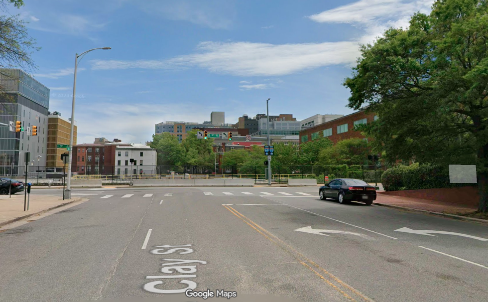 A google street view of an empty plot of land and an old looking street