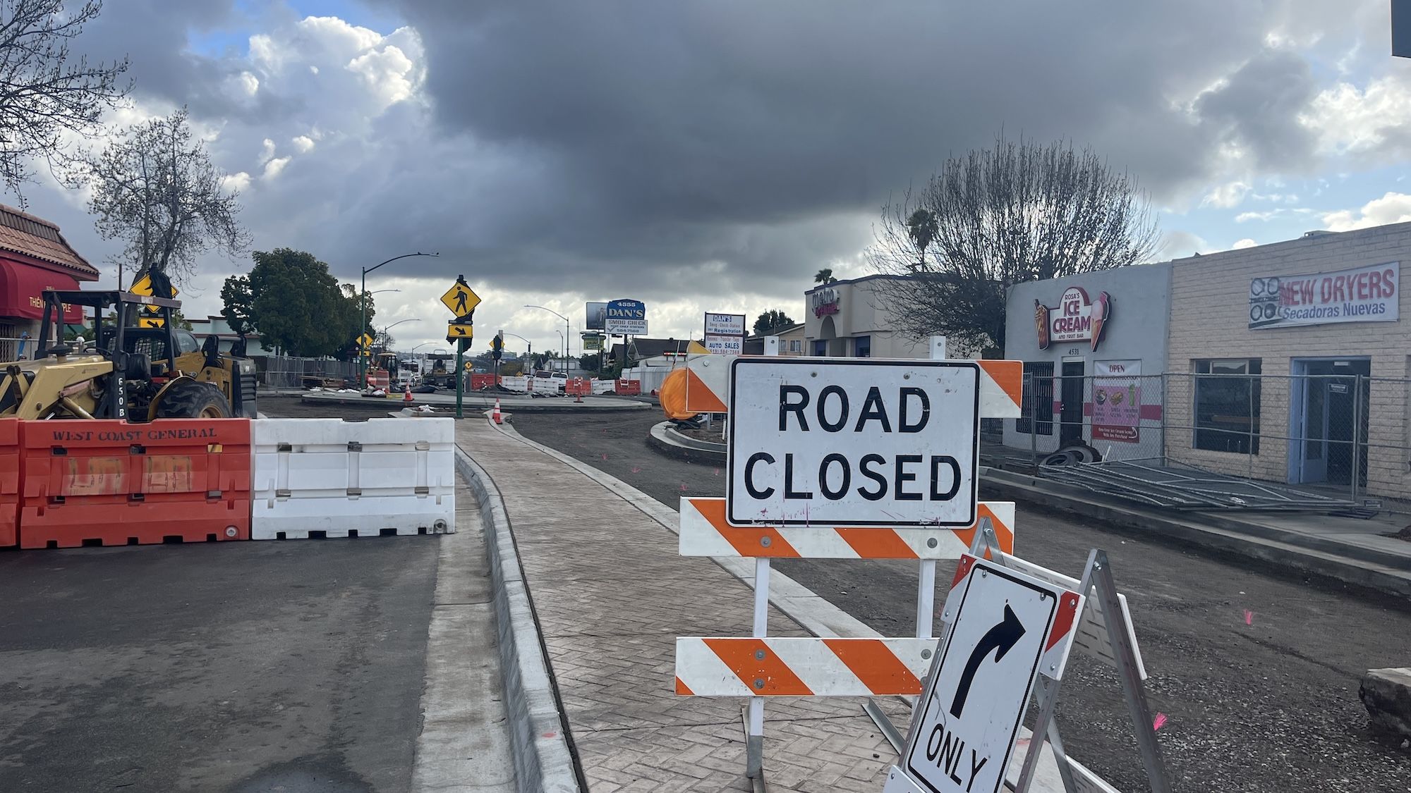 Construction signs and barricades show a road is closed.