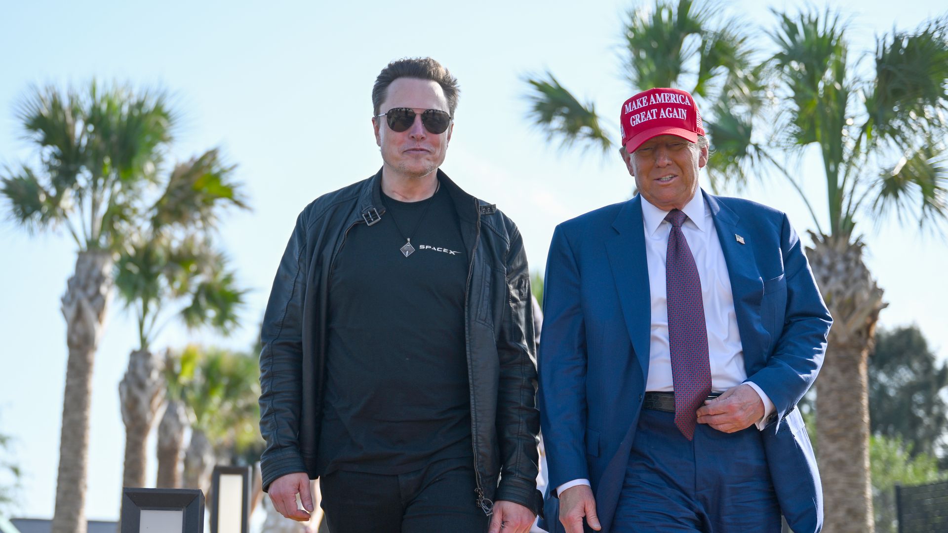 Trump and Musk walk side by side.