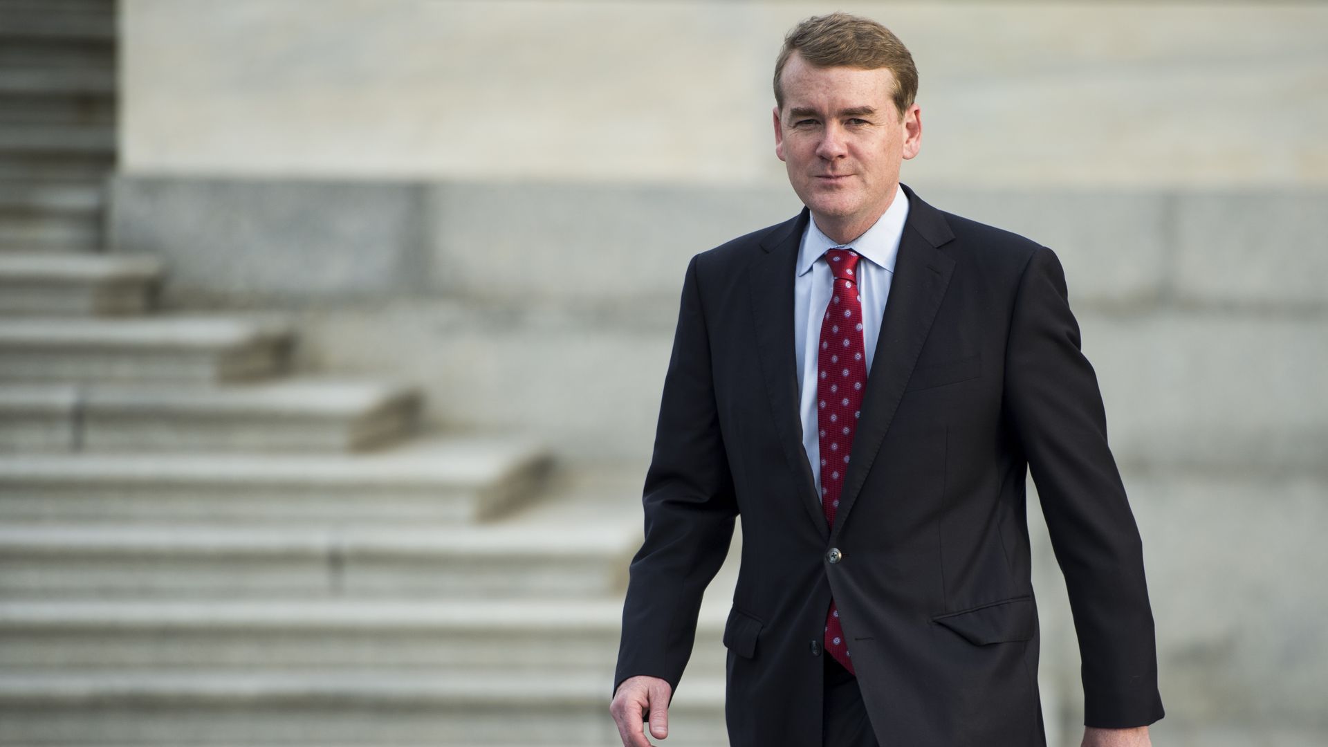 Sen. Bennett walks with a suit on. 