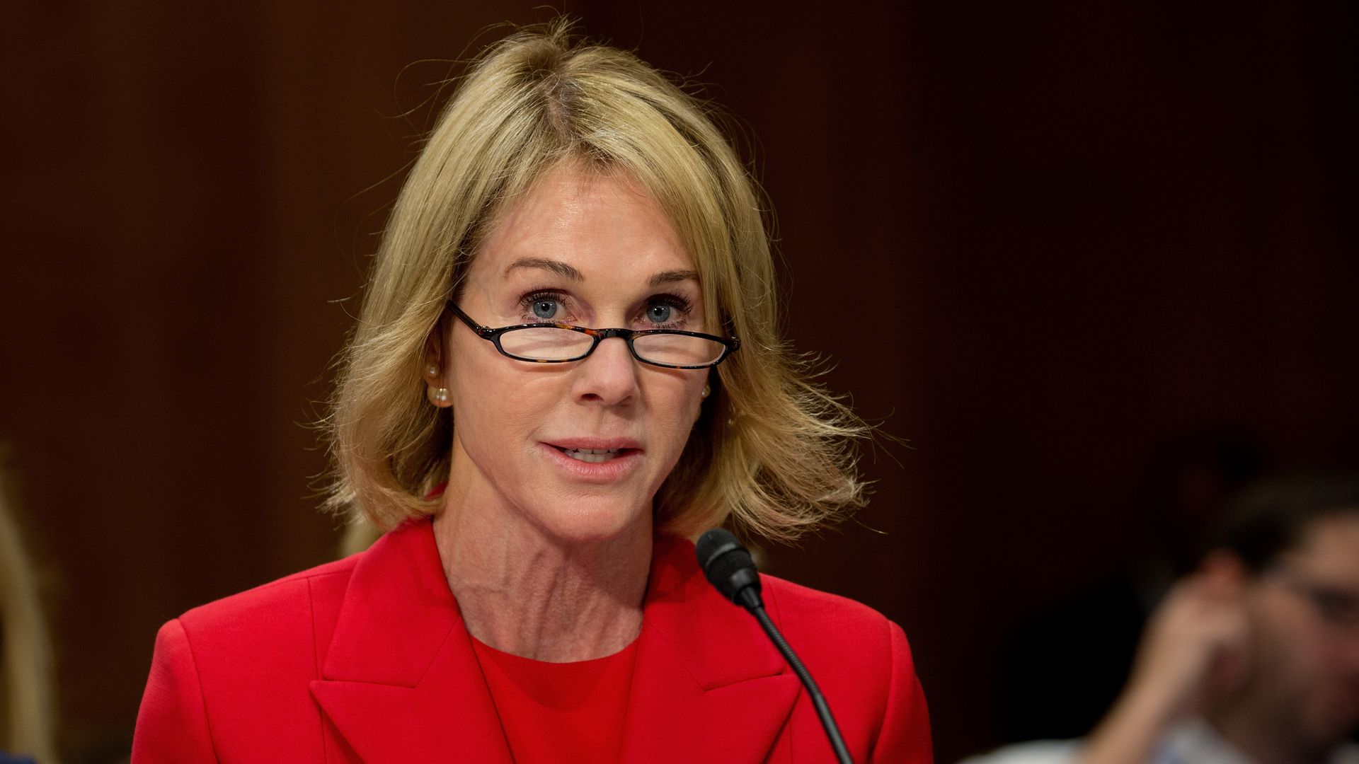 In this image, Kelly sits in front of a microphone.
