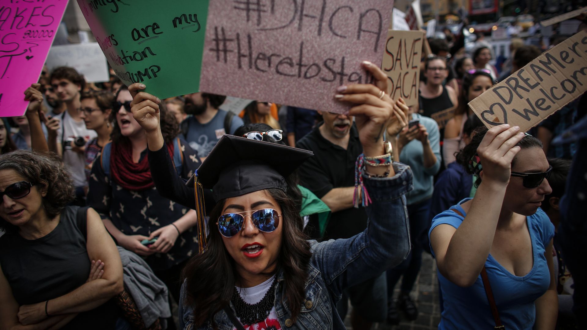 NEW YORK, NY - SEPTEMBER 09: A woman holds a placard as she takes part during a march in protest of President Trump's decision on DACA in front of a Trump Hotel on September 9, 2017 in New York City. 