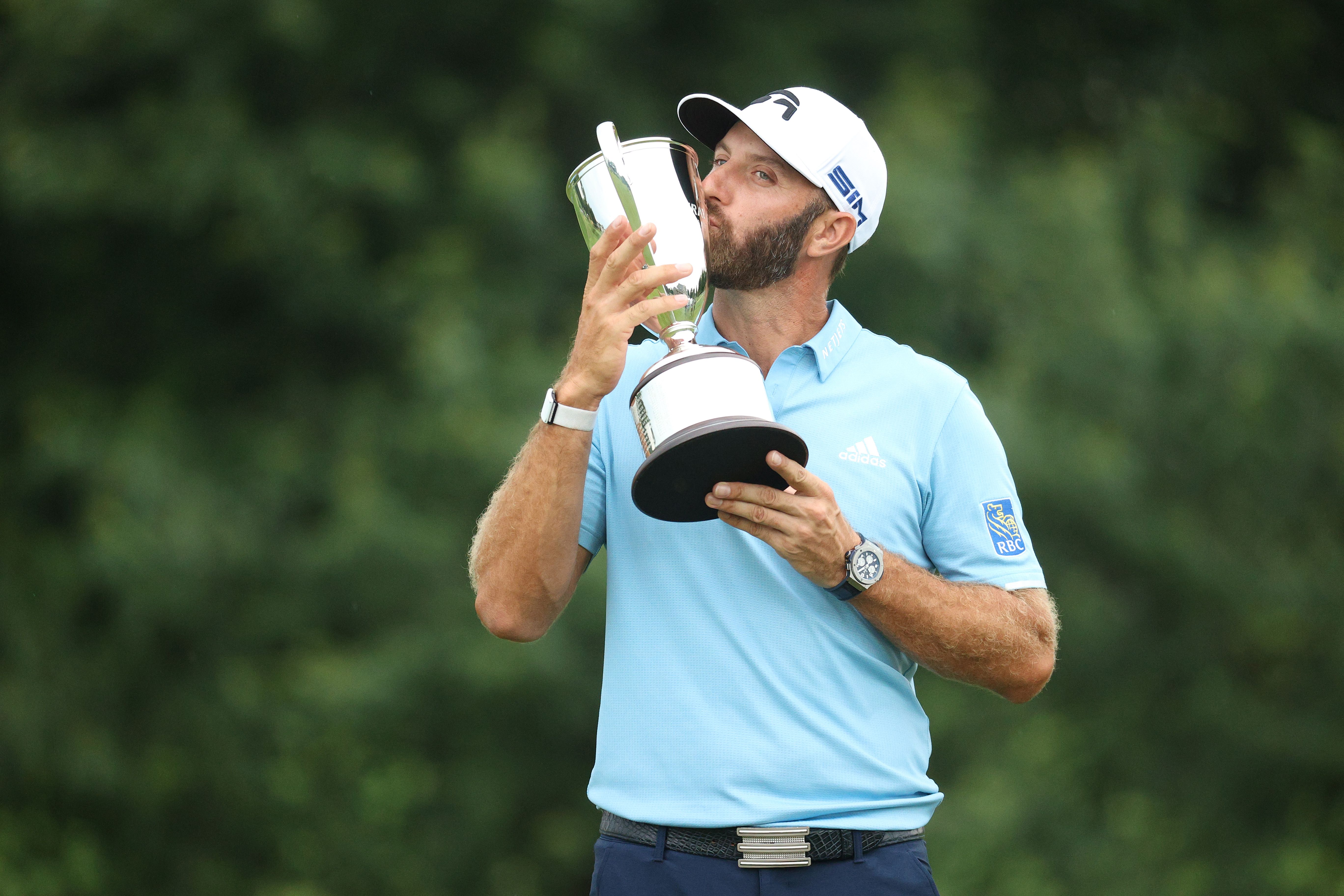 Dustin Johnson kisses the trophy