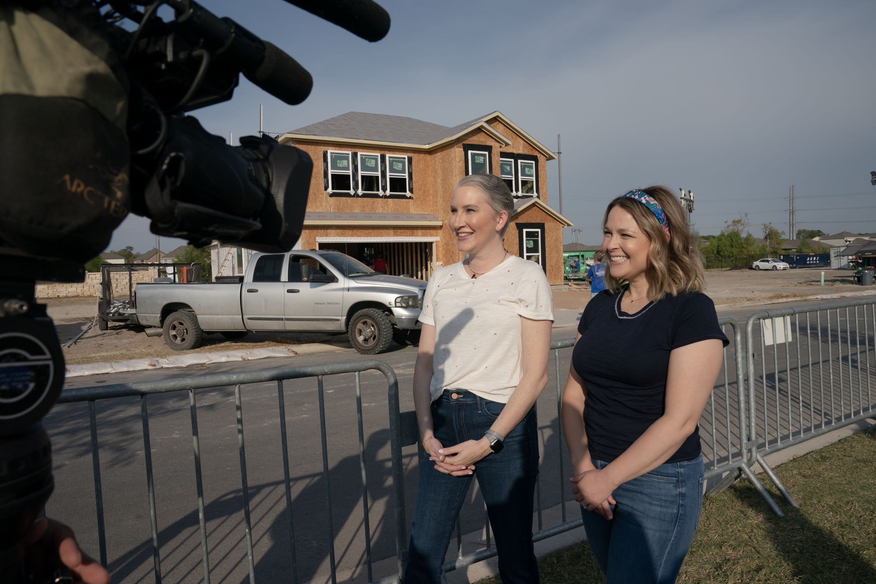 A photo of the shows two hosts in front of the Hutto home.