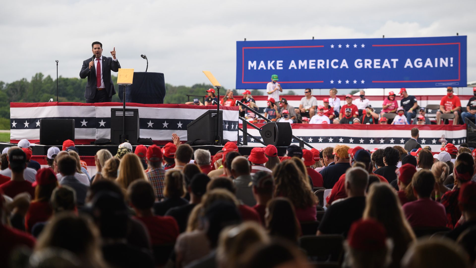 Photo of Sean Parnell speaking from a stage to a crowd of MAGA supporters