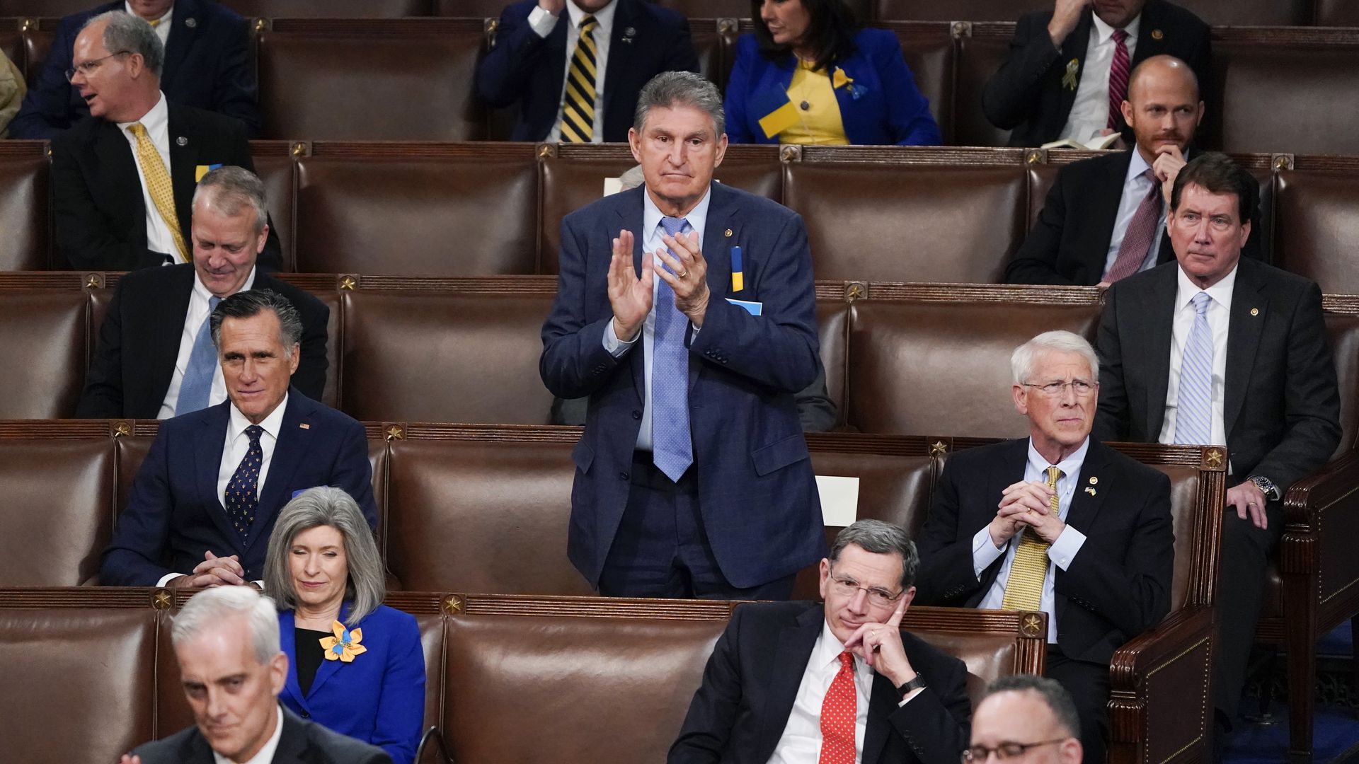 Sen. Joe Manchin is seen standing and clapping while seated between Republicans for the State of the Union address.
