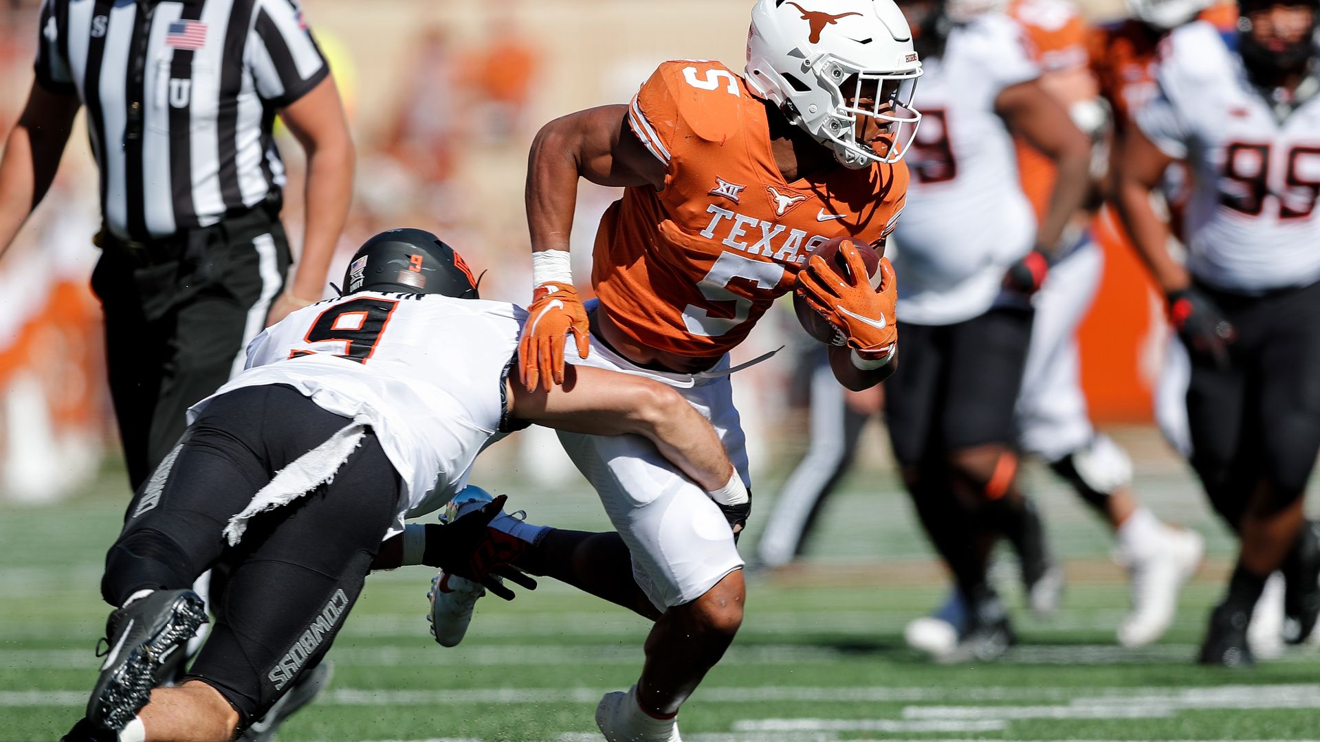 Bijan Robinson of the University of Texas attempts to elude a would-be Oklahoma State tackler.