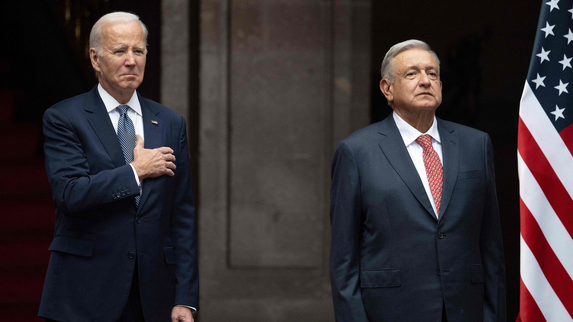 President Biden holds his hand to his chest and Mexican President Andres Manuel Lopez Obrador, who is standing next to him, stands at attention