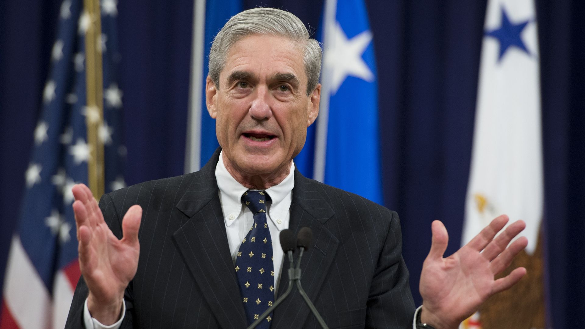 Bob Mueller gestures while speaking with his hands up.