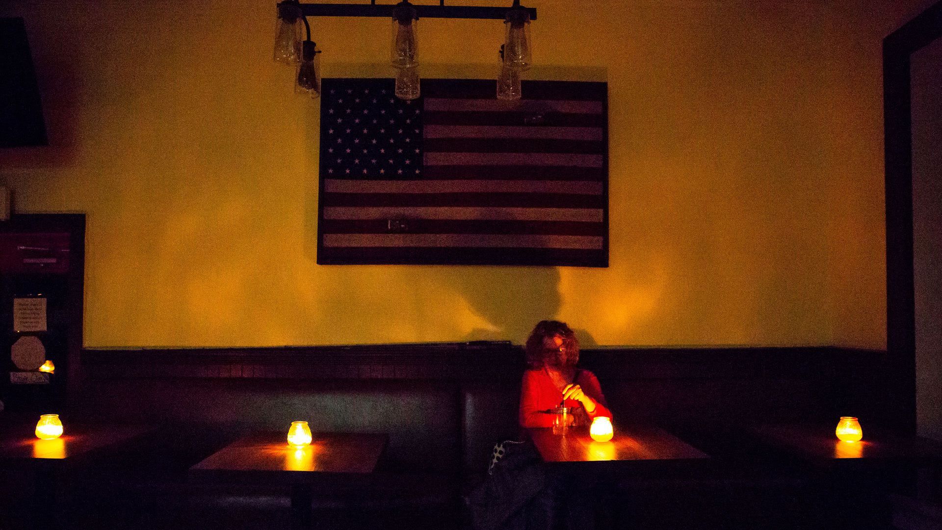 A woman sitting in a restaurant without electricity