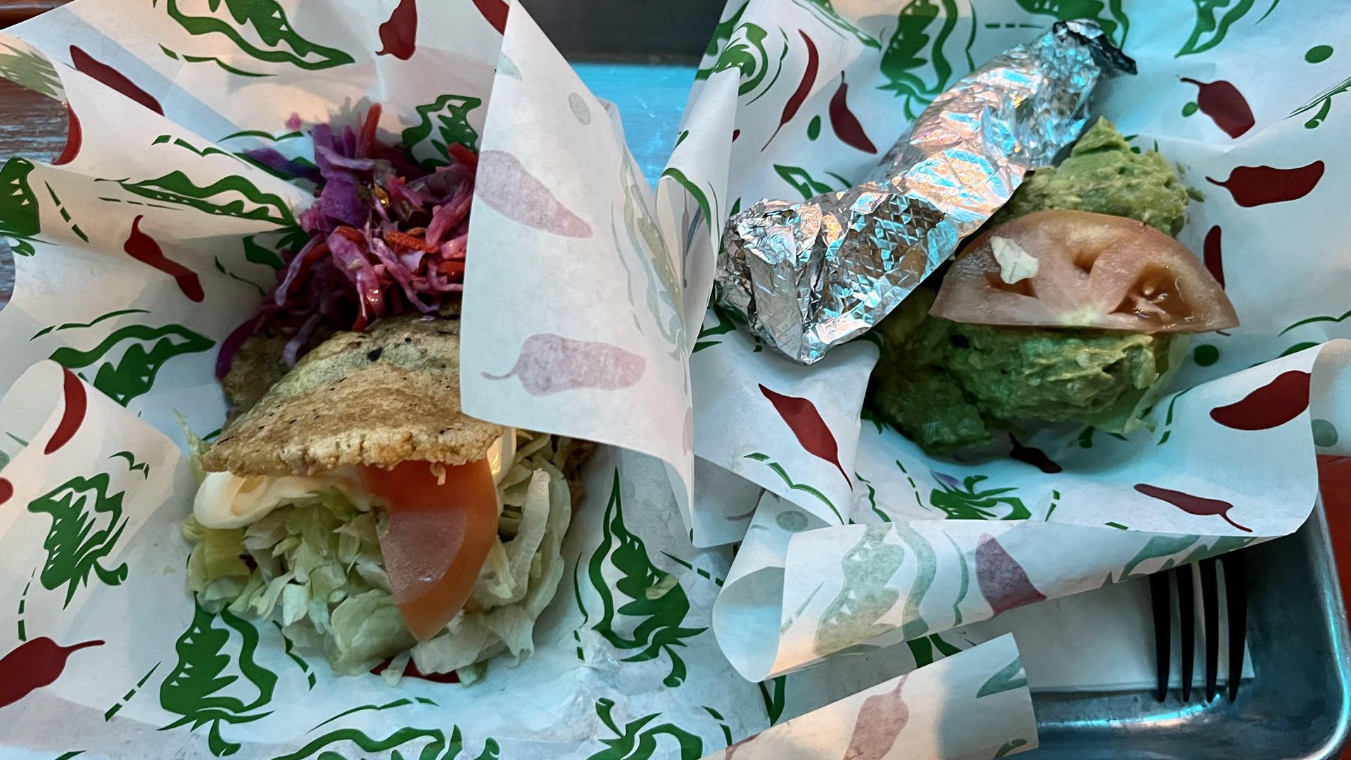 A gordita and guacamole on a platter.