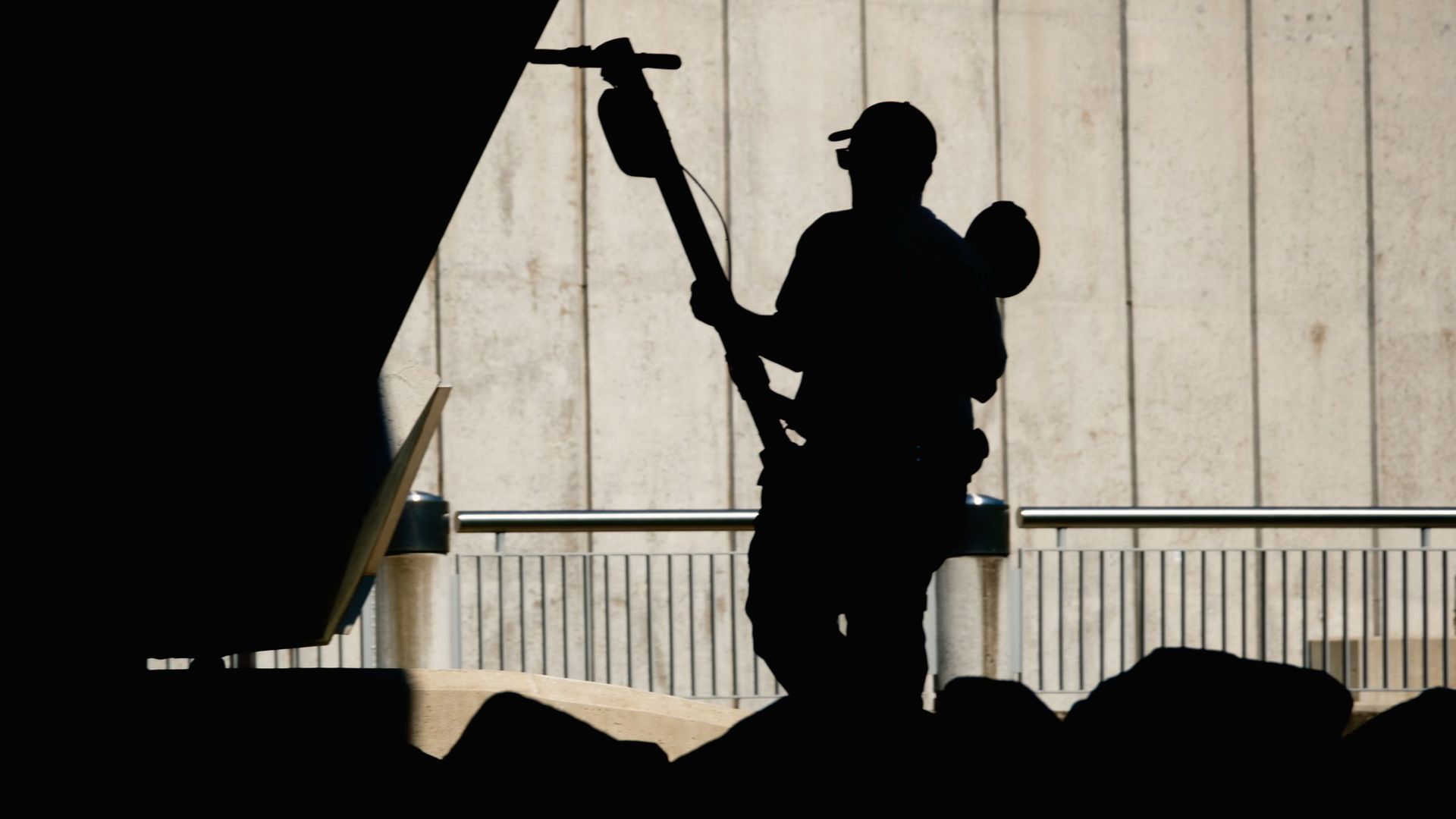 The silouhette of a Metro Parks ranger pulling an electric scooter from the Scioto River under the Rich Street Bridge