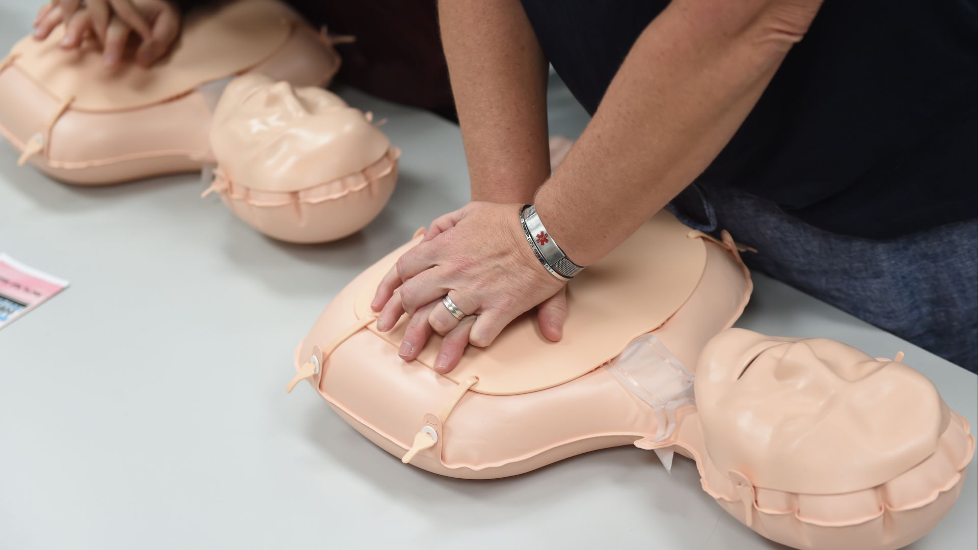 A person presses on a CPR dummy