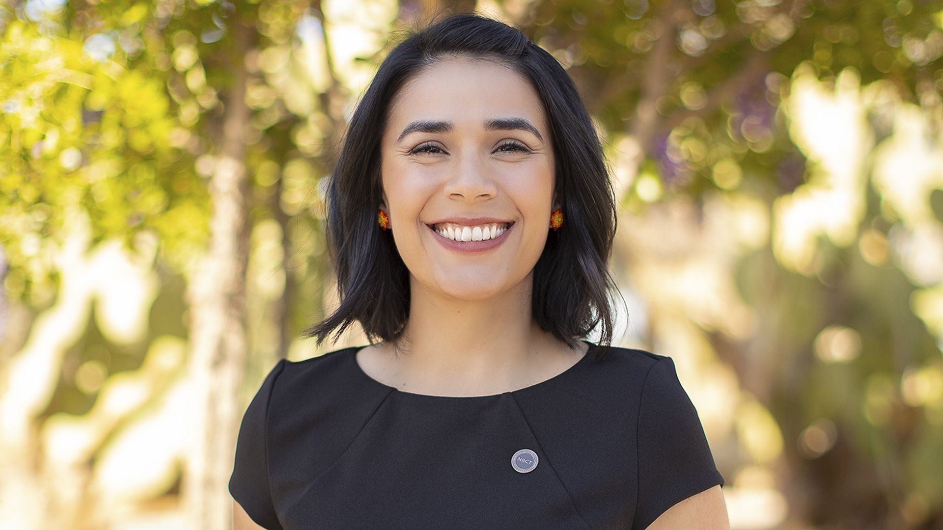 Juliana Urtubey, the 2021 National Teacher of the Year, stands in front of trees.