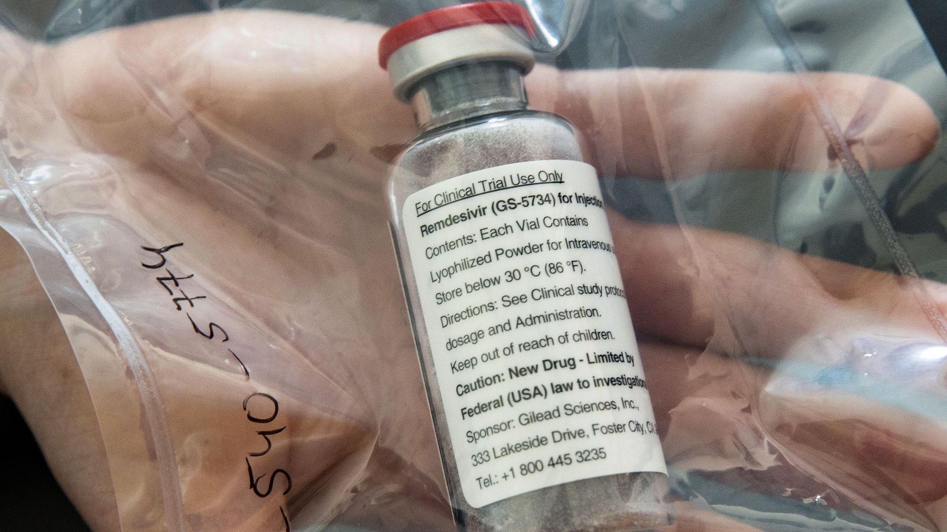 A clear bottle of the IV drug remdesivir with a while label.