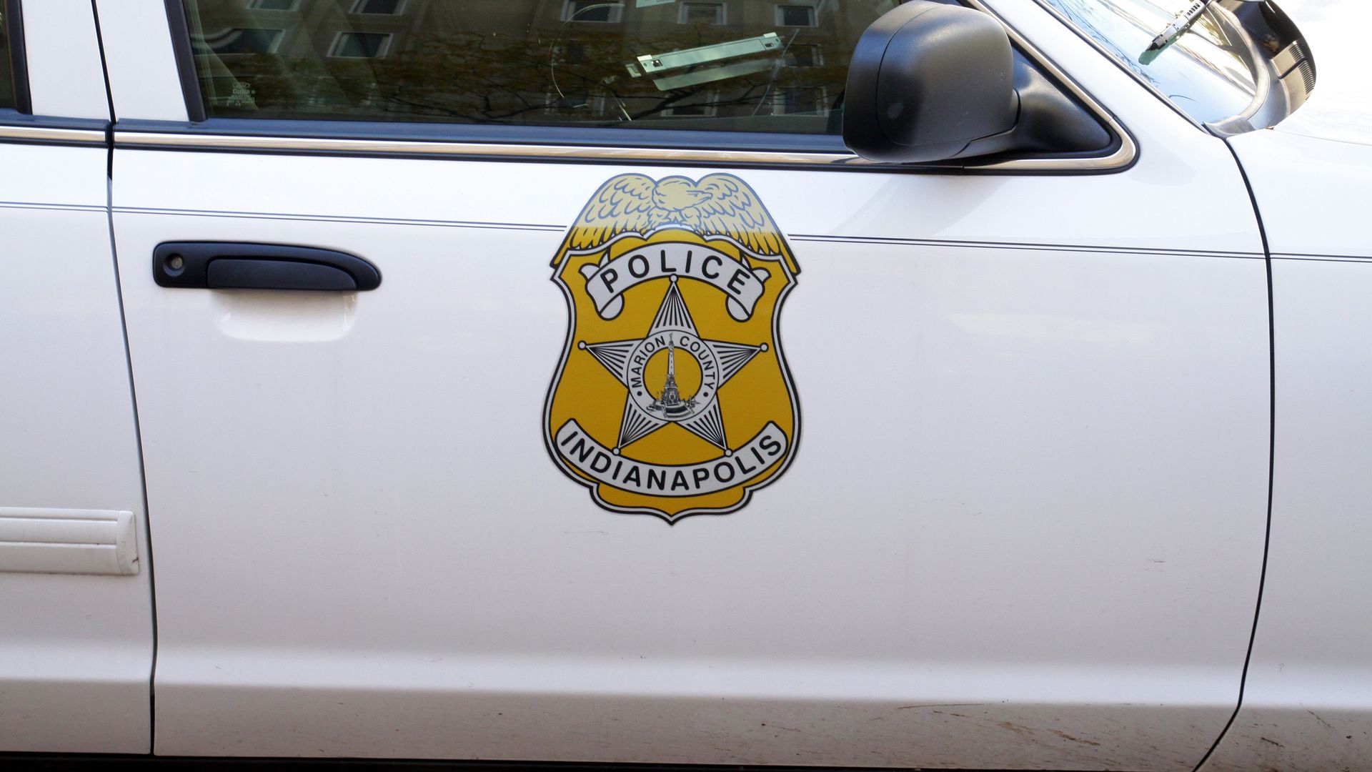 An Indianapolis Metropolitan Police Department logo on the side of a police car.