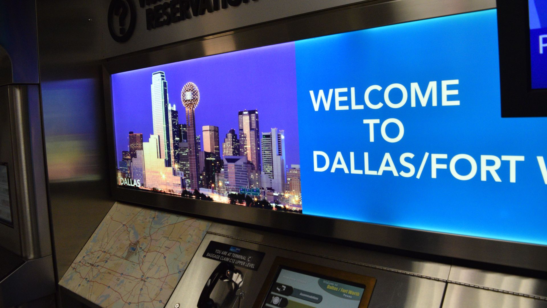 A welcome sign at DFW airport, and a phone for reasons that are not clear