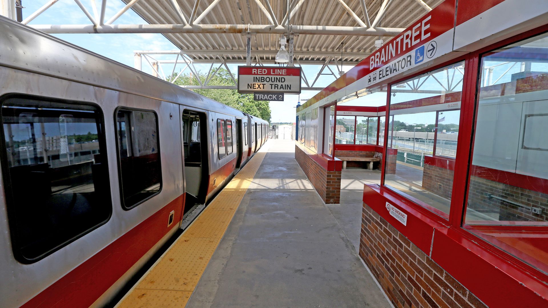 A Red Line train stops at the Braintree station, and the platform is empty.