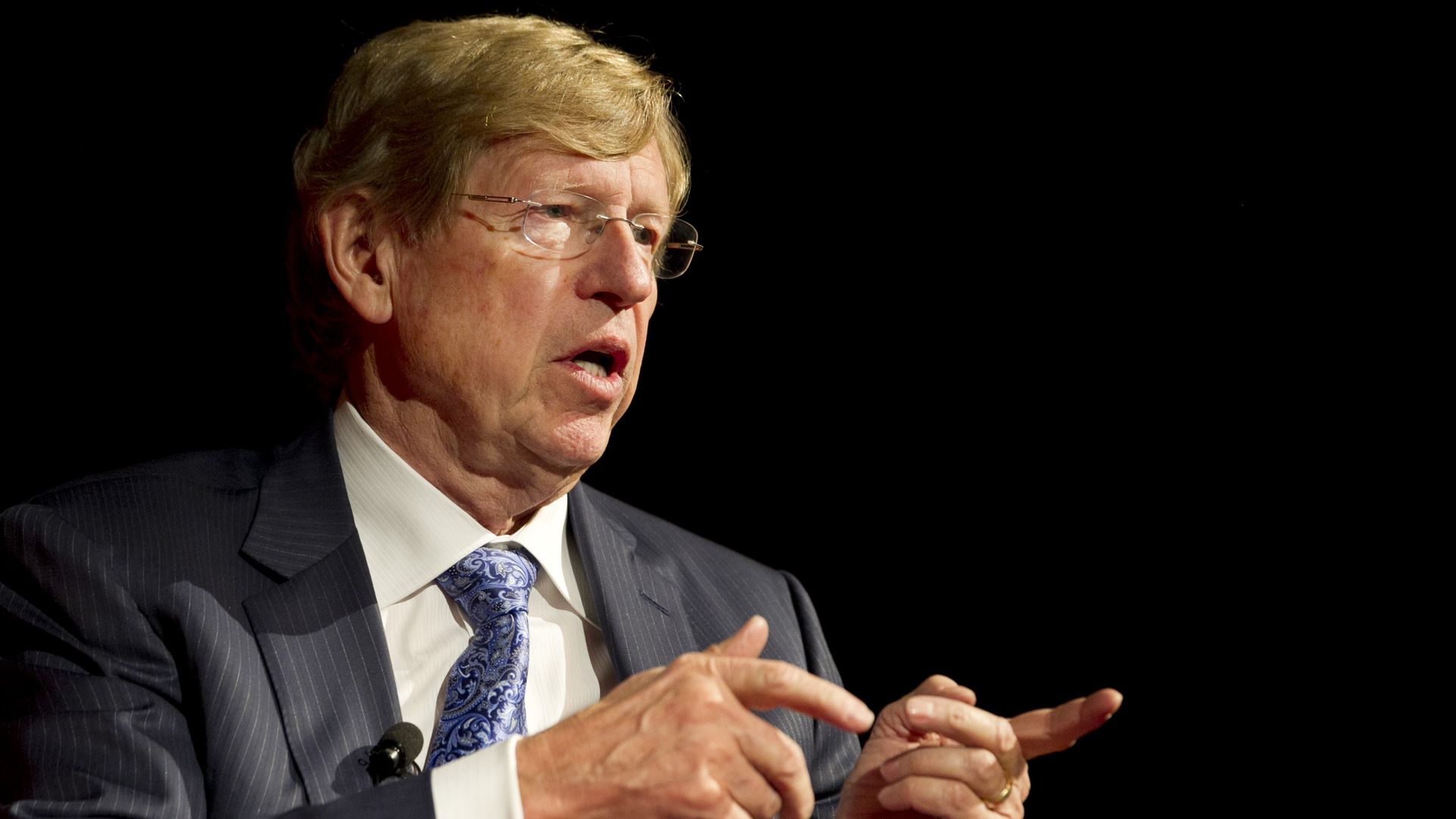 Lawyer wearing glasses points with finger while talking