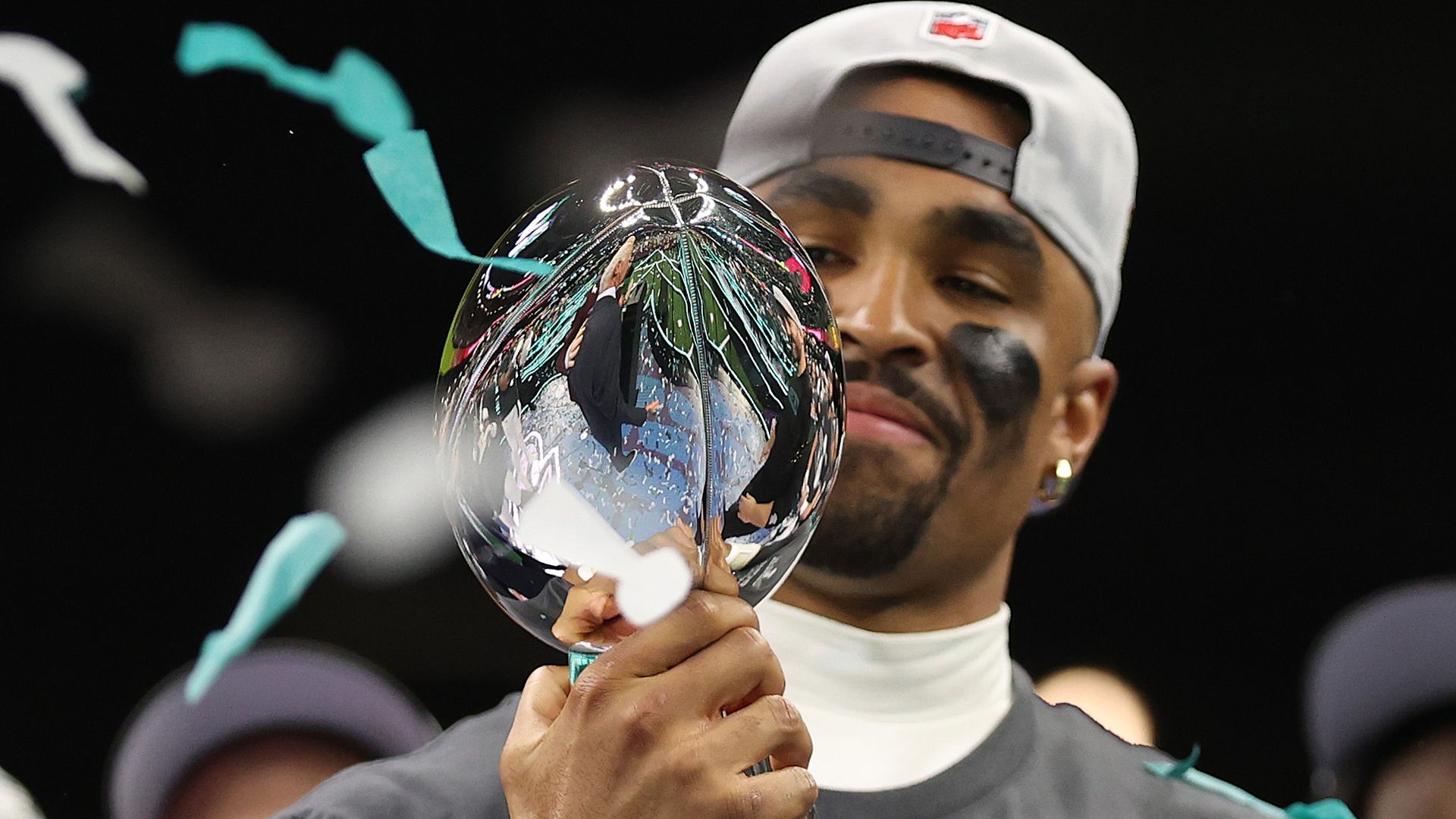 A close-up of Eagles quarterback Jalen Hurts clutching the Vince Lombardi Trophy after beating the Kansas City Chiefs in Super Bowl LIX.