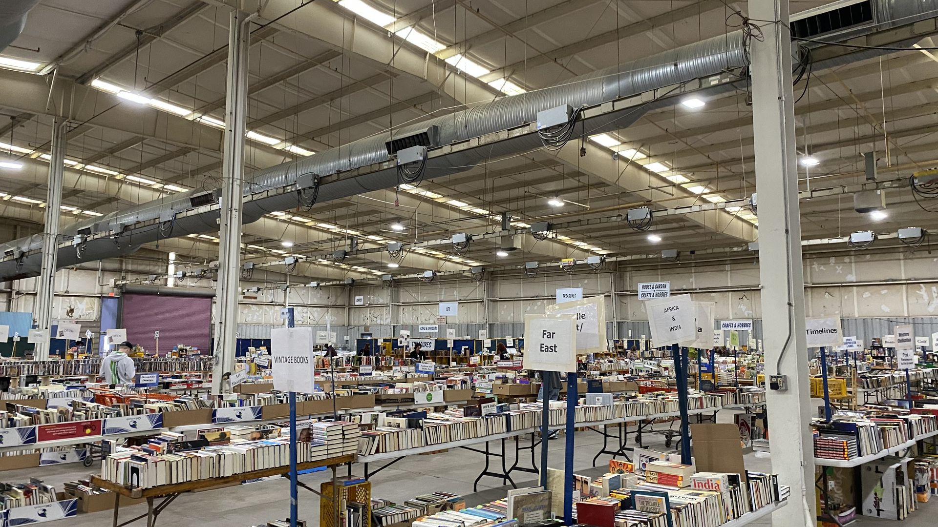 A large building full of long tables filled with books.