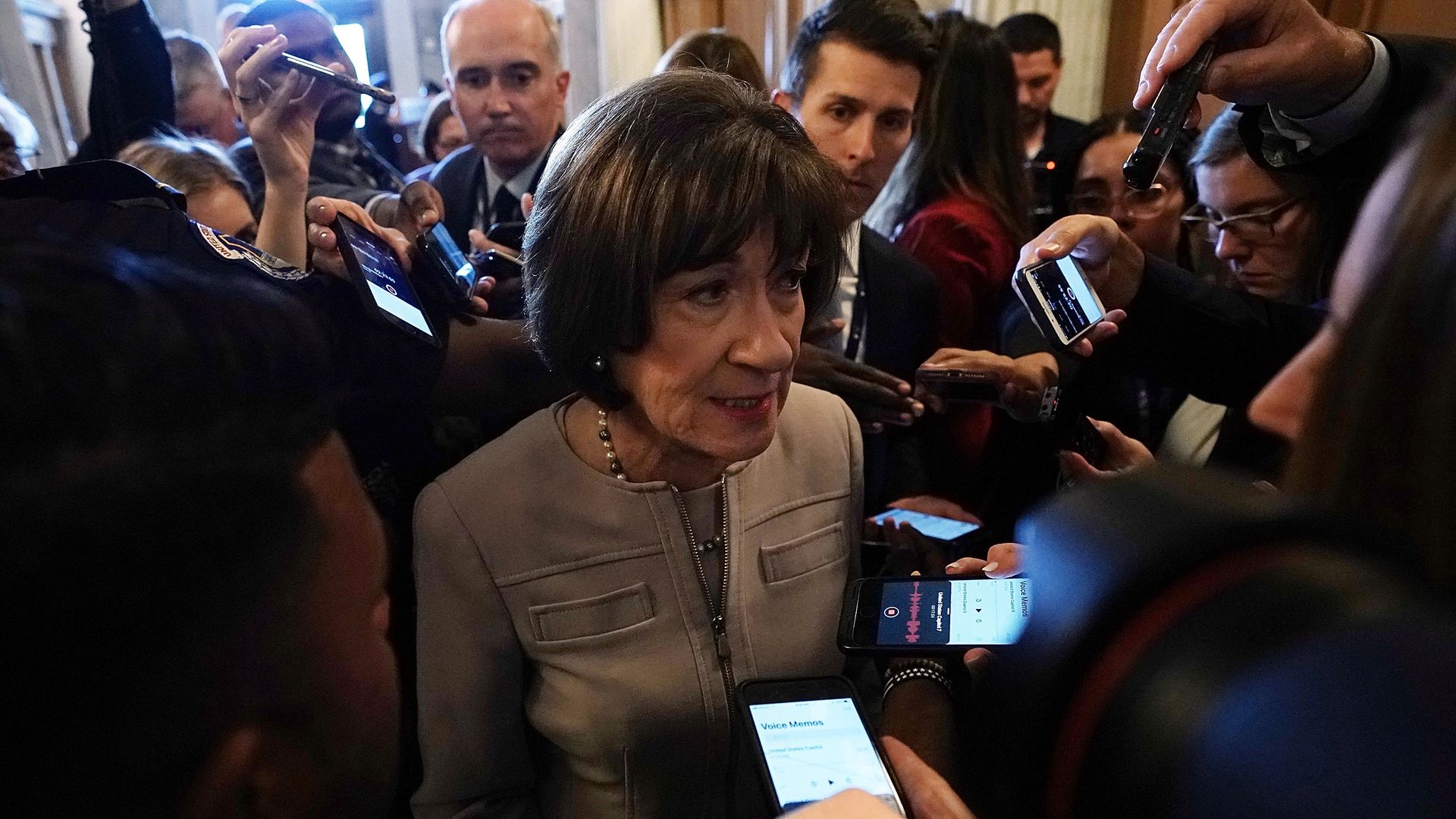 Susan Collins surrounded by reporters