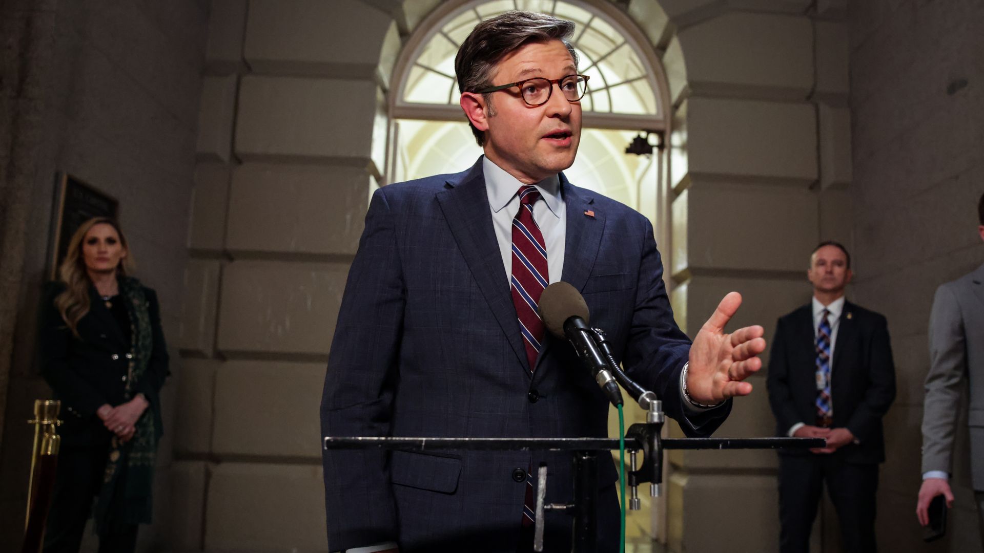 Speaker Mike Johnson speaks on the Hill, with his left hand raised