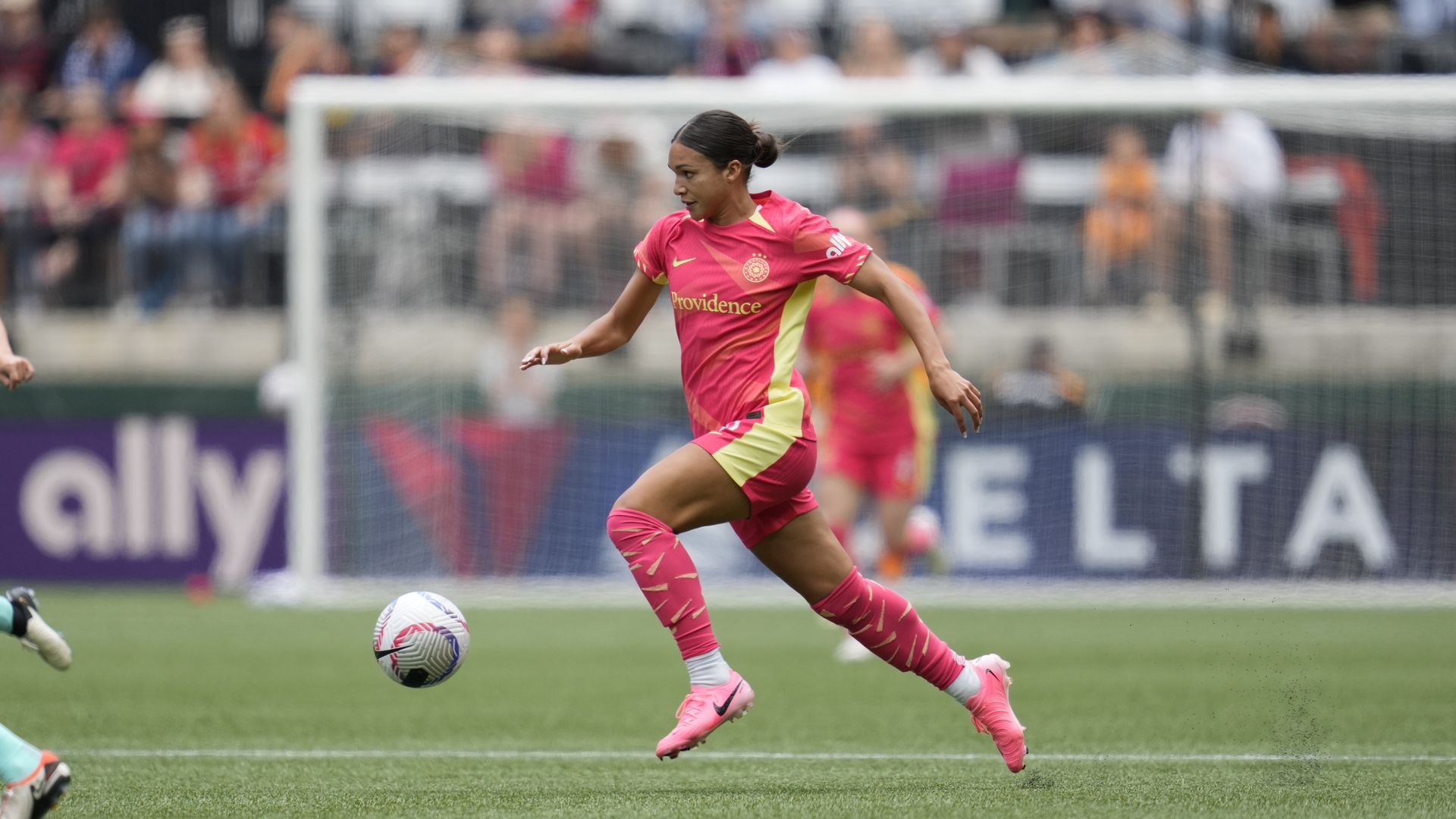 A photo of a person running and kicking a soccer ball.