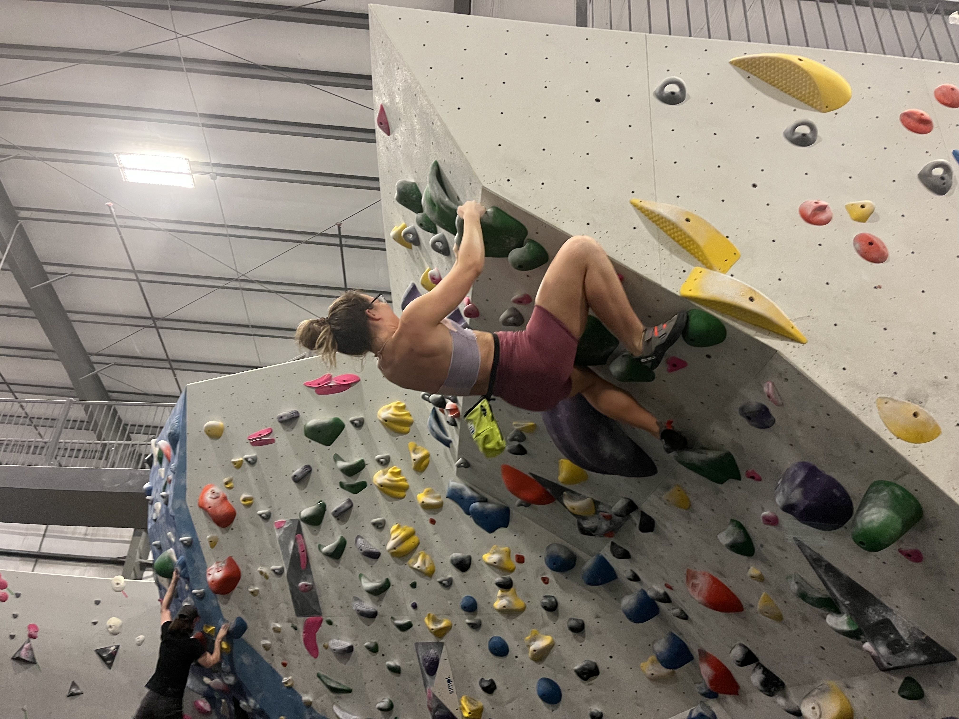 A person climbing a rock climbing wall at nearly a 90-degree angle