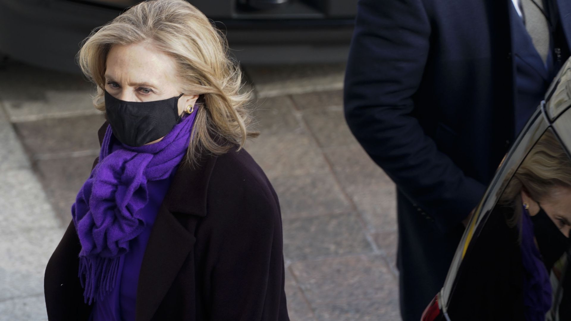 Photo of a masked Hillary Clinton walking up the stairs