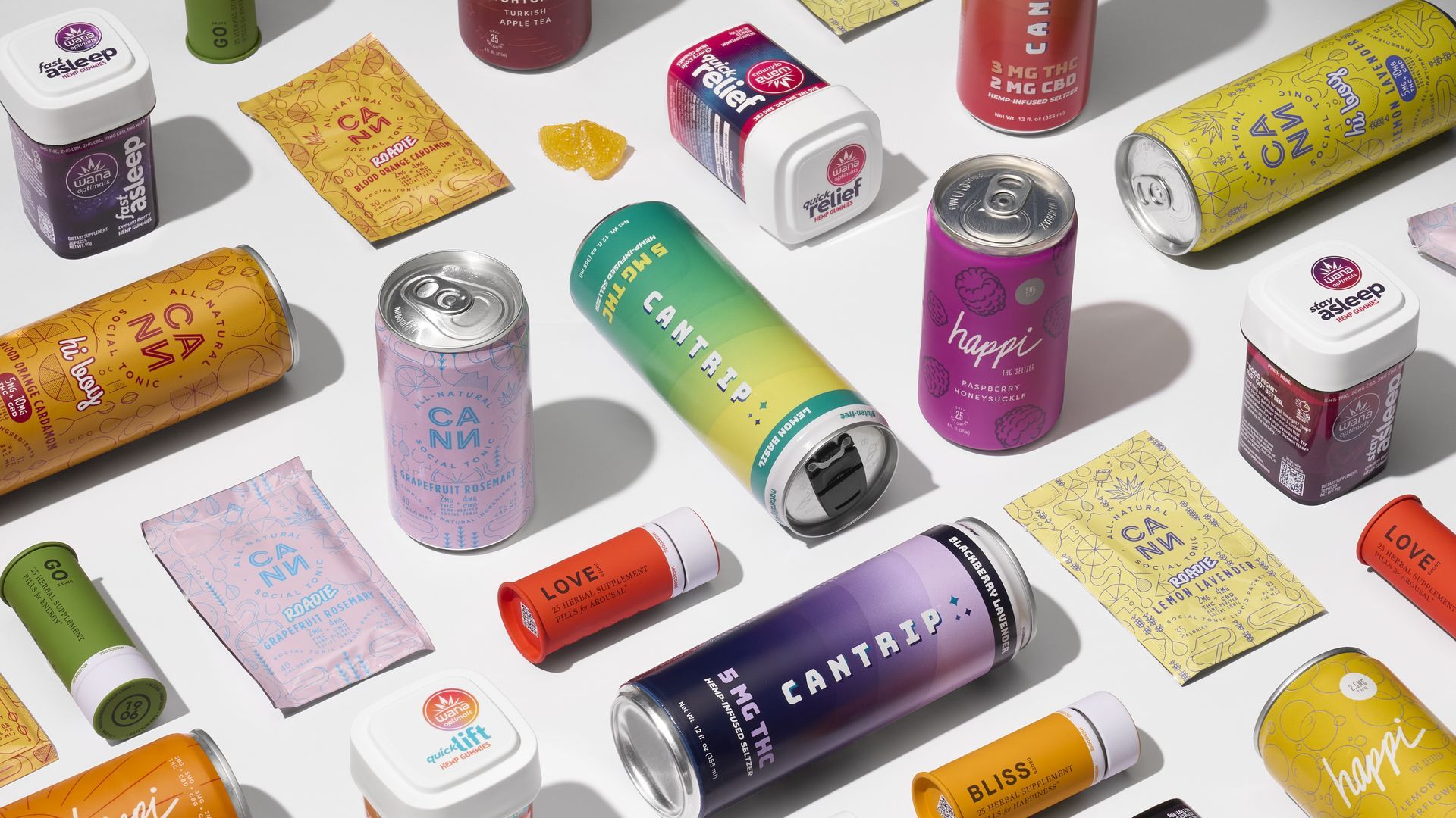 Various colorful hemp and herbal supplement products including cans, gummies, and packets with labels like Cantrip, Happi, Wana, Love, Go, and Bliss arranged on a white surface.