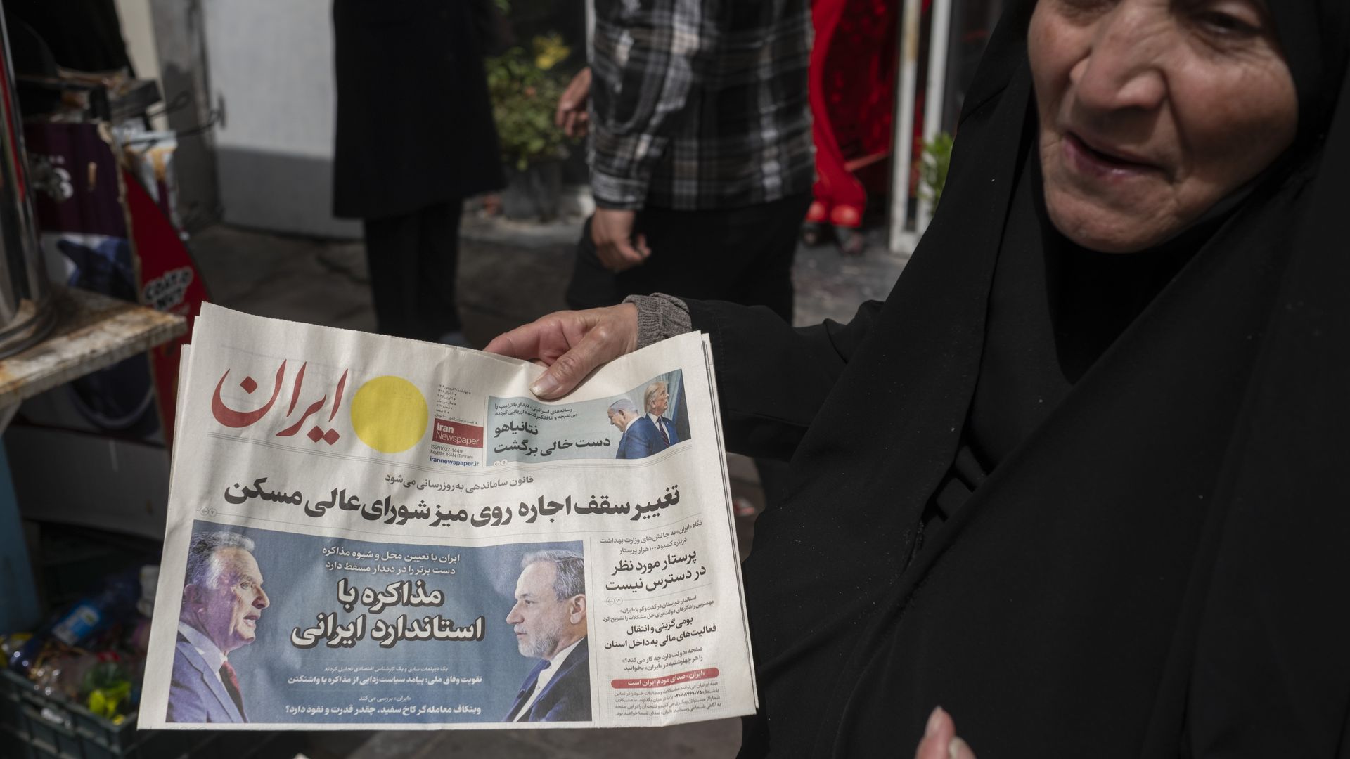 زنی ایرانی در تهران، ایران، در حال حمل روزنامه‌ای است که تصویری از عباس عراقچی، وزیر امور خارجه ایران و استیو ویتکوف، فرستاده ویژه کاخ سفید را نشان می‌دهد. عکس: مرتضی نیکوبزل/نورفوتو از طریق گتی ایمیجز