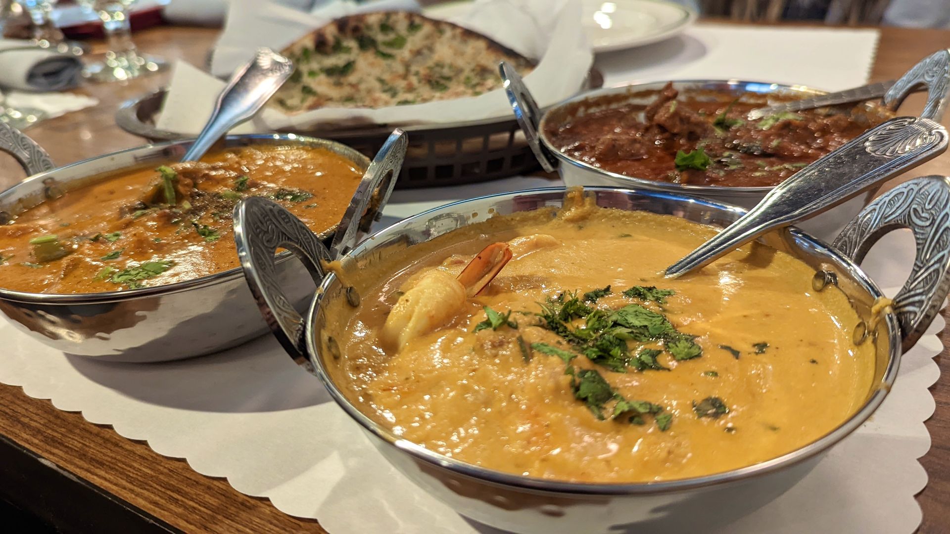 Shrimp coconut kurma, front, with chicken tikka masala, left and chettinad lamb, right, at Bombay Palace restaurant in Murray. Photo: Erin Alberty/Axios