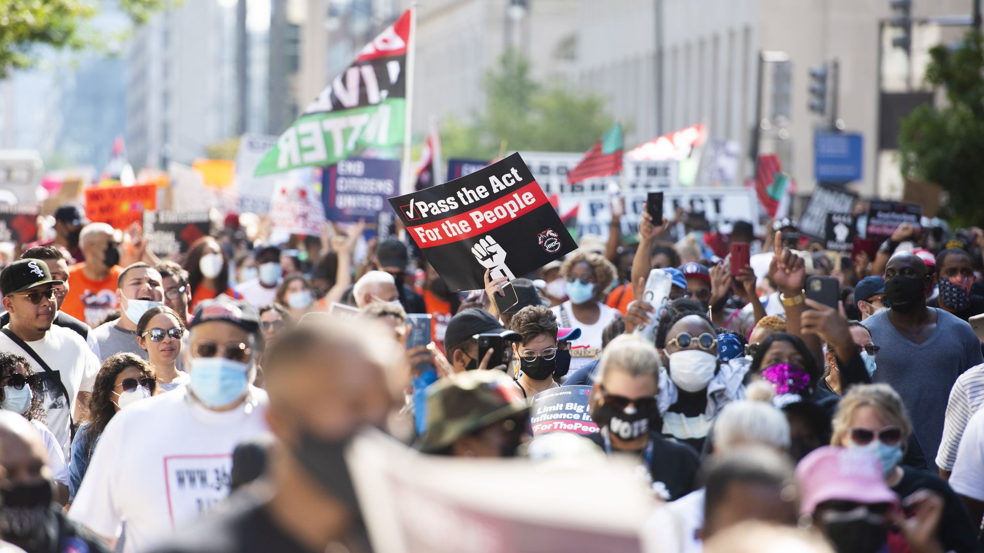 Demonstrators hold signs while walking during the March On for Washington and Voting Rights rally in Washington, D.C., U.S., on Saturday, Aug. 28, 2021