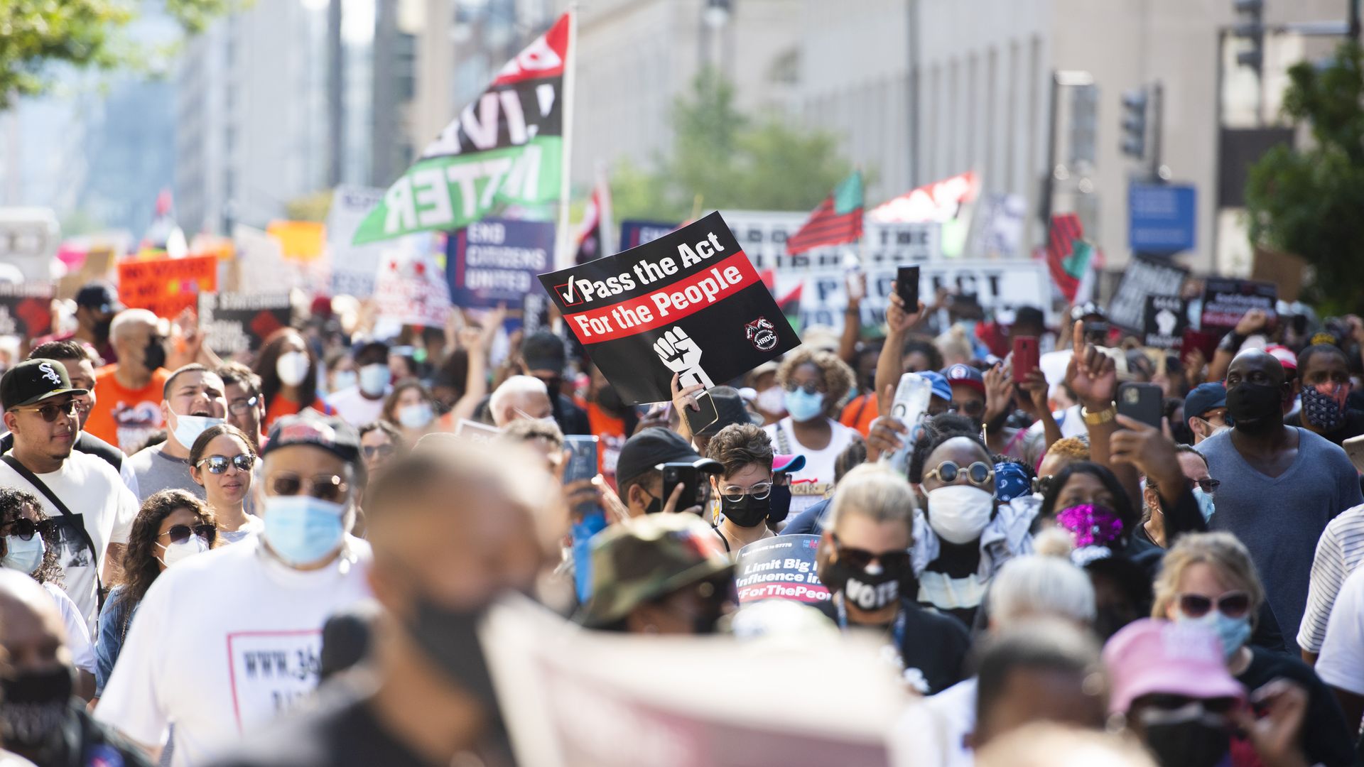 Demonstrators hold signs while walking during the March On for Washington and Voting Rights rally in Washington, D.C., U.S., on Saturday, Aug. 28, 2021