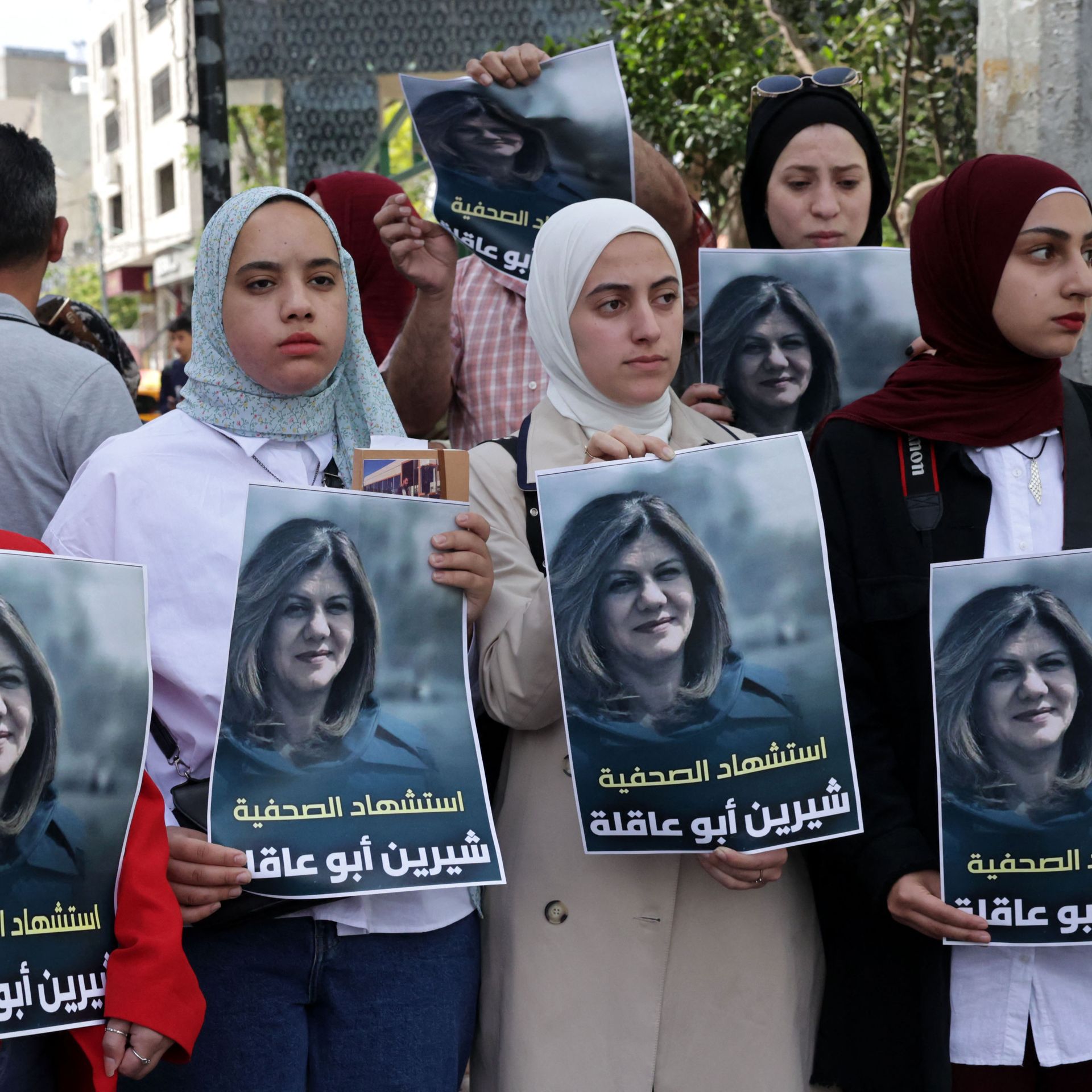 Palestinians hold posters displaying veteran Al Jazeera journalist Shireen Abu Aqleh on May 11 in Hebron. Photo: