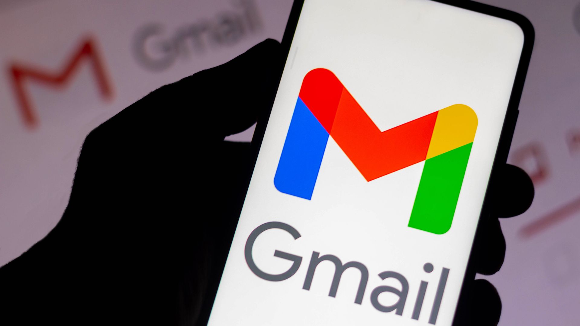 In this photo illustration the Google Gmail logo seen displayed on a smartphone and in the background. 