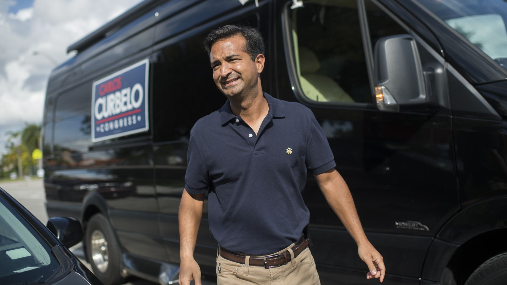 Carlos Curbelo walks outside of his campaign van