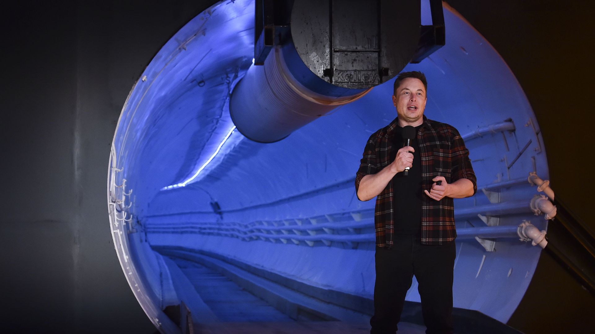 Image shows Elon Musk in front of a tunnel.