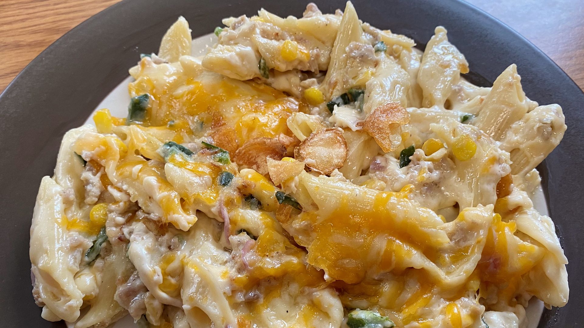 A brown and white plate piled with mac and cheese