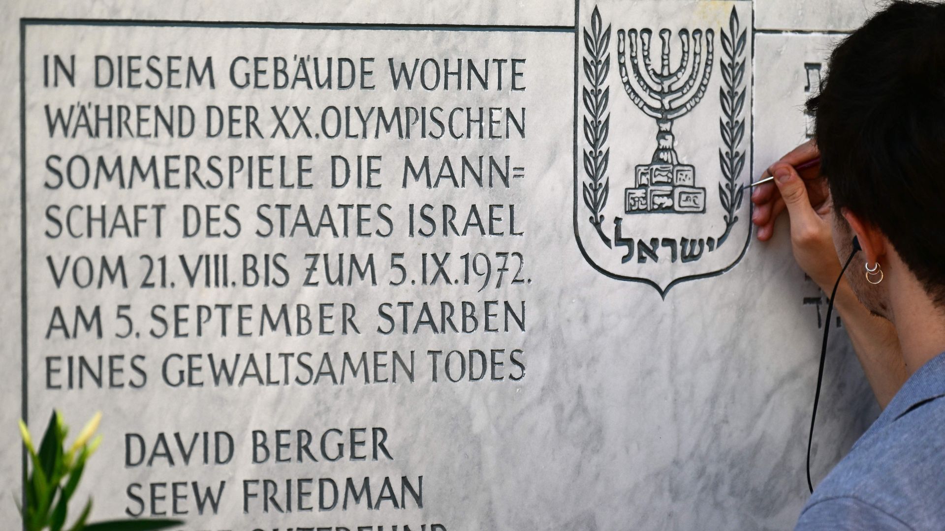 A man repaints a memorial at the former housing of Israel's 1972 Olympic team at the Conollystrasse street 31 at the Olympic Village.
