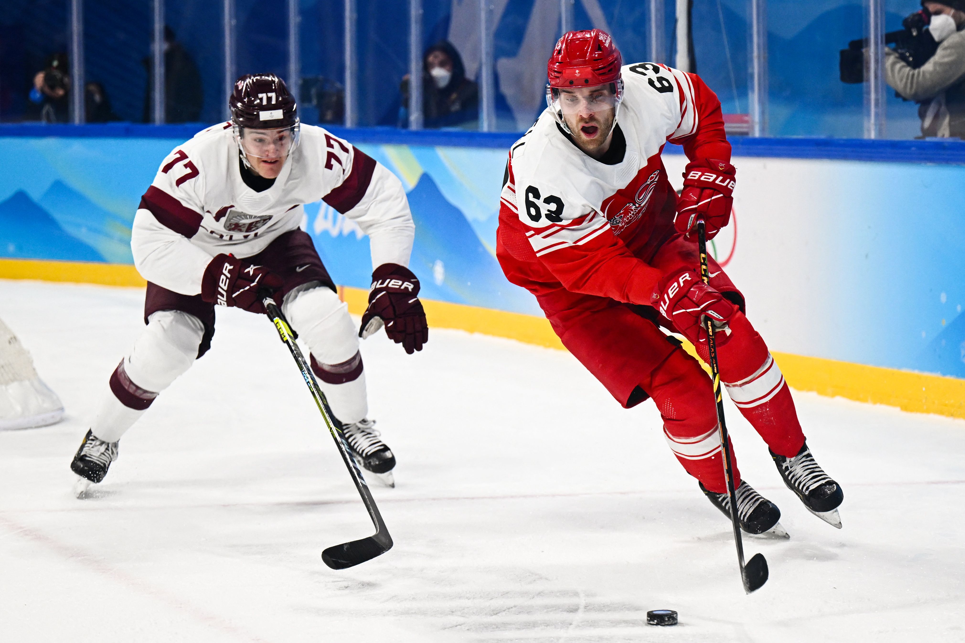 Denmark's Patrick Russell (R) controls the puck during the Olympic men's qualification play-off match of the Beijing