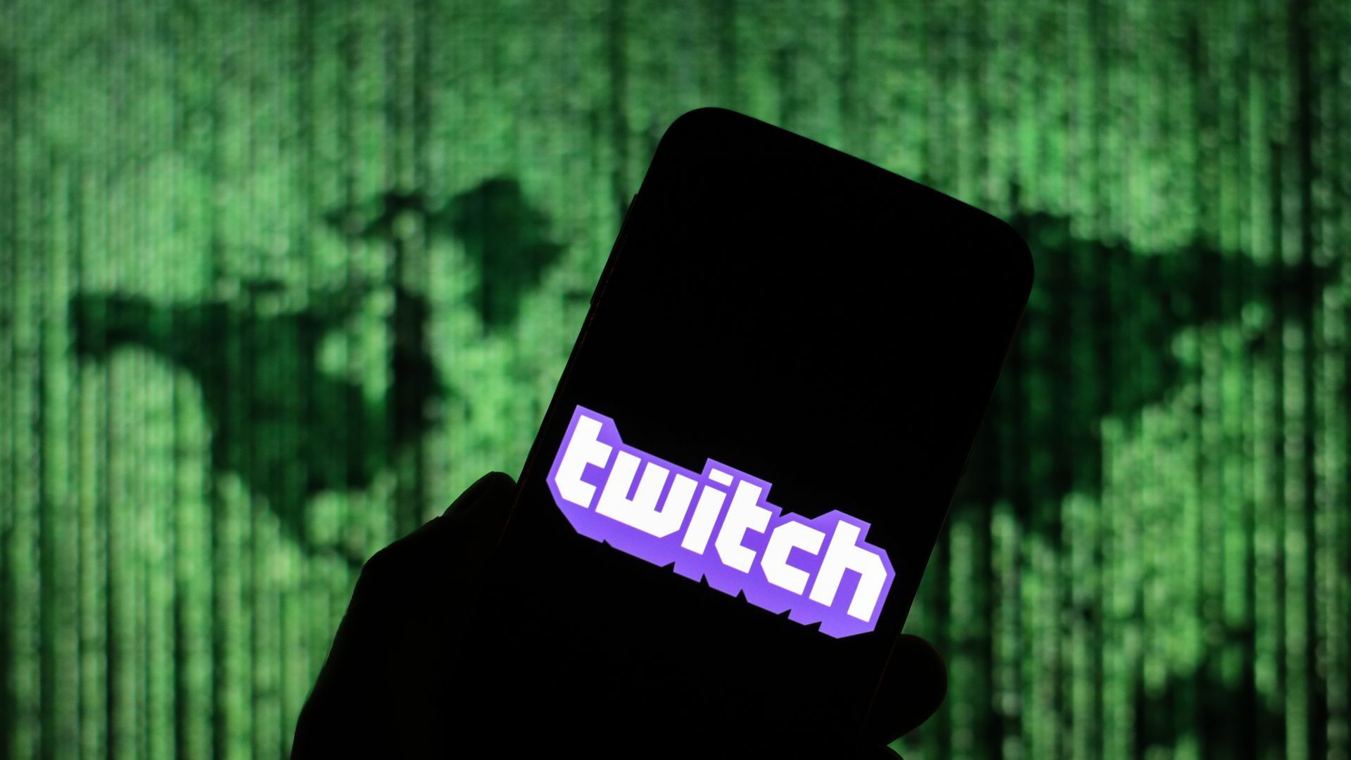 A person holding a phone that has a Twitch logo on it.