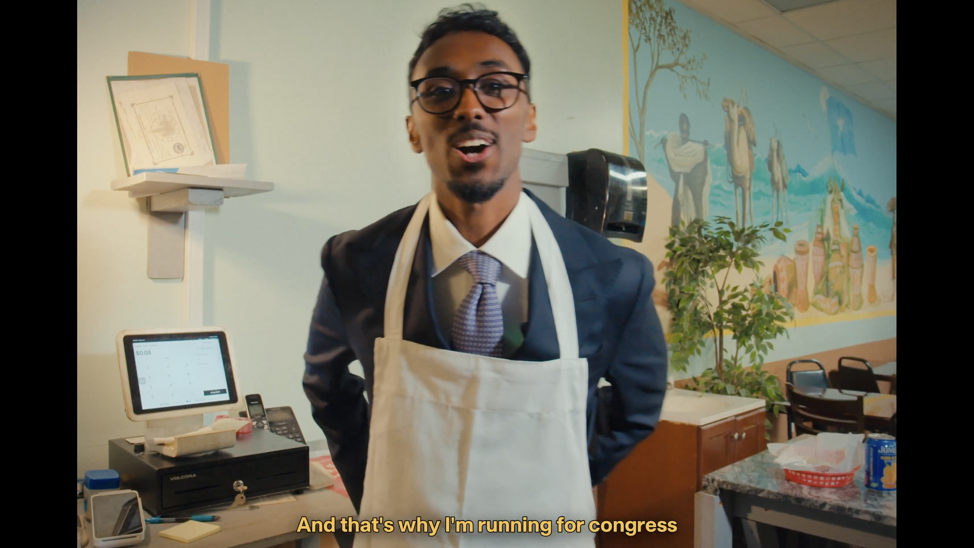 A man in an apron at a restaurant.