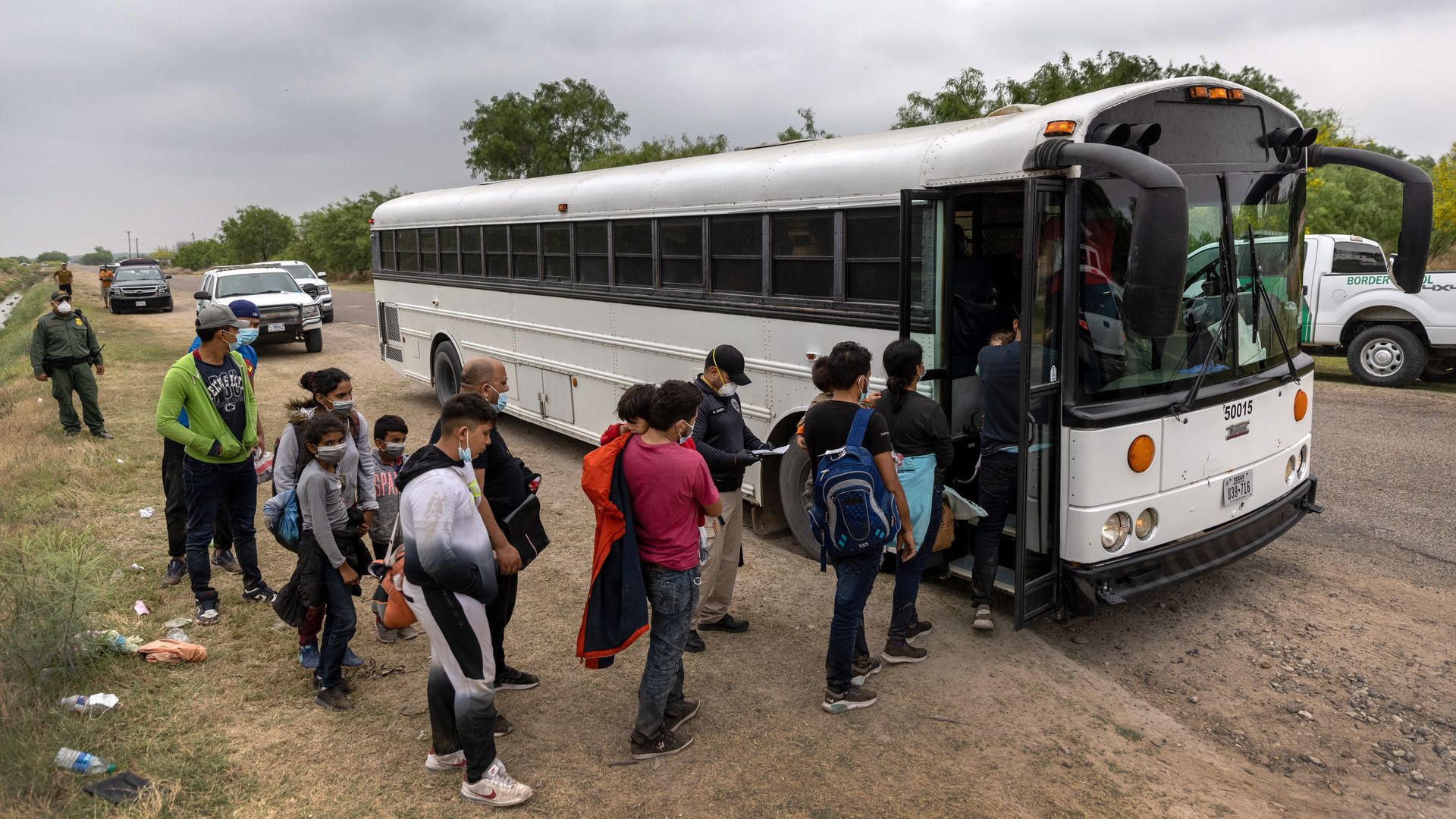 Central American families board a U.S. Customs and Border Protection bus for transport to an immigrant processing center after crossing the border from Mexico 