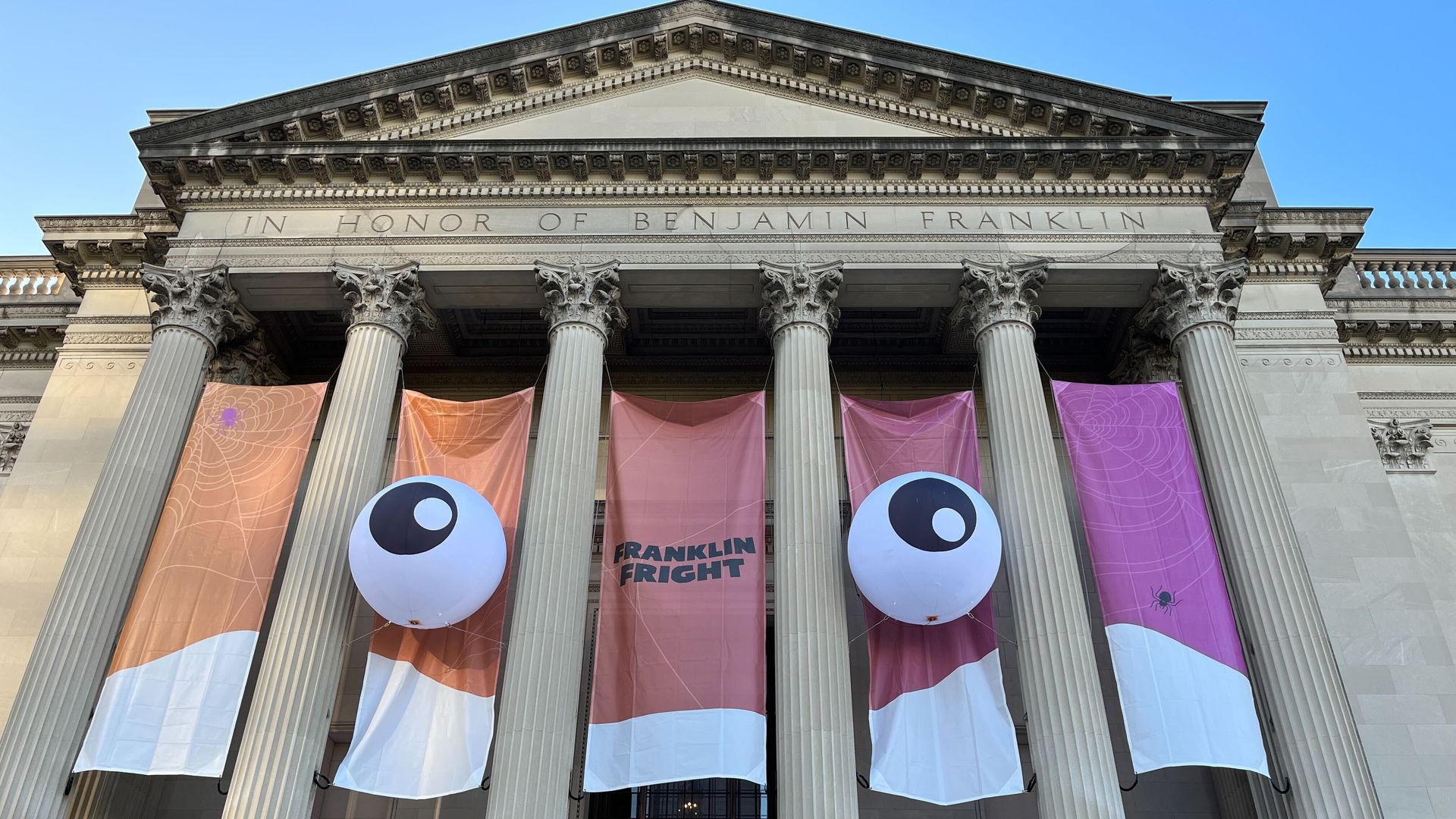A Halloween-themed banner with giant eyeballs hangs outside the Franklin Institute in Philadelphia.