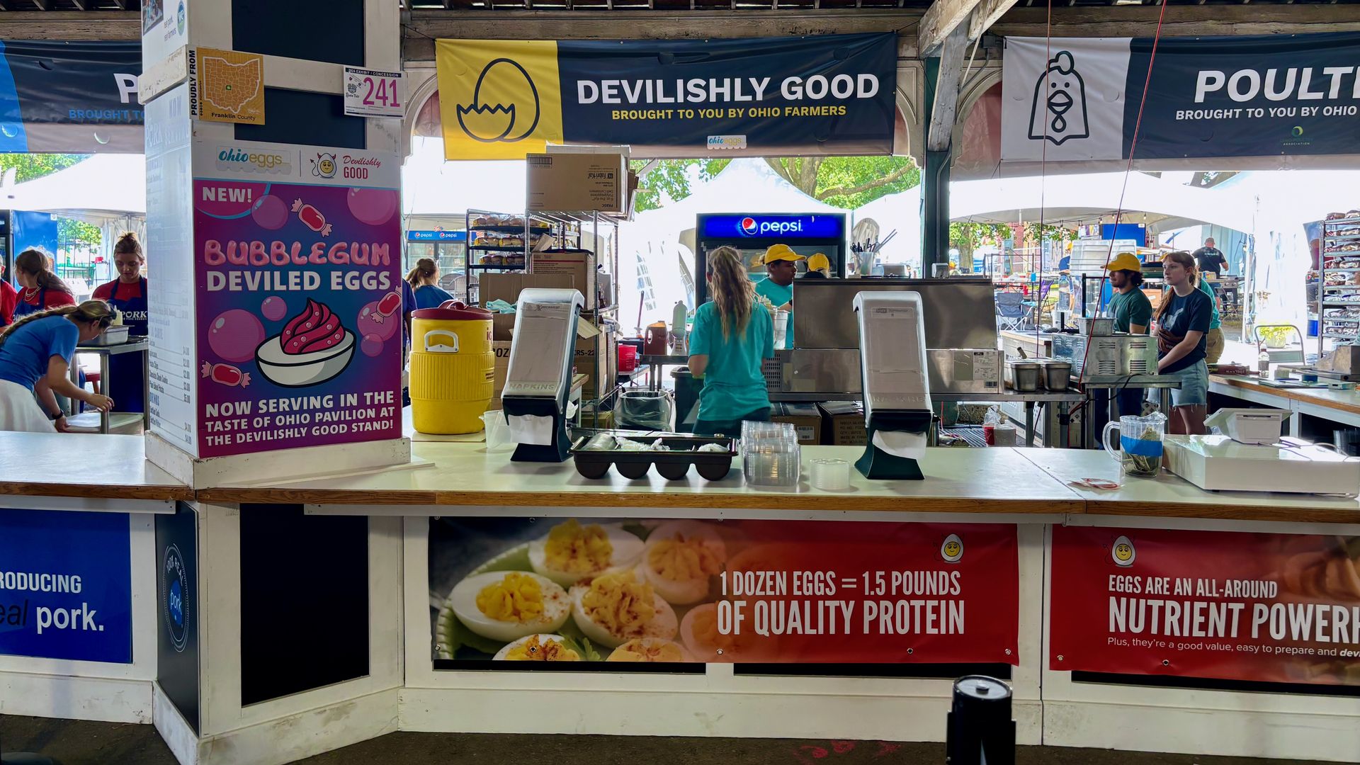 A view from the line of the Devilishly Good stand at the Ohio State Fair, with an add for bubblegum deviled eggs