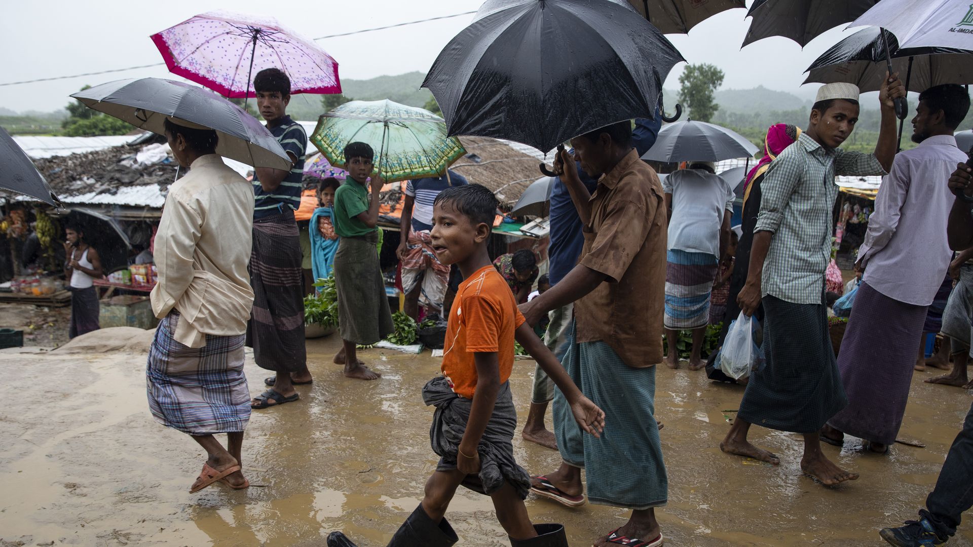 Monsoon rains hit the refugee camps as Rohingya walk through a local market August 28, 2018 in Unchiprang refugee camp, Cox's Bazar, Bangladesh. 